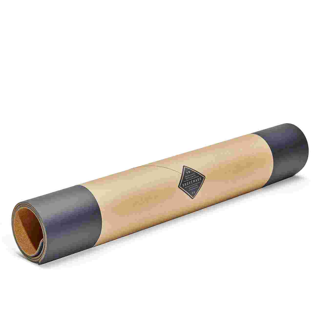 Large matte black desk pad, rolled in brown craft paper for easy gifting.