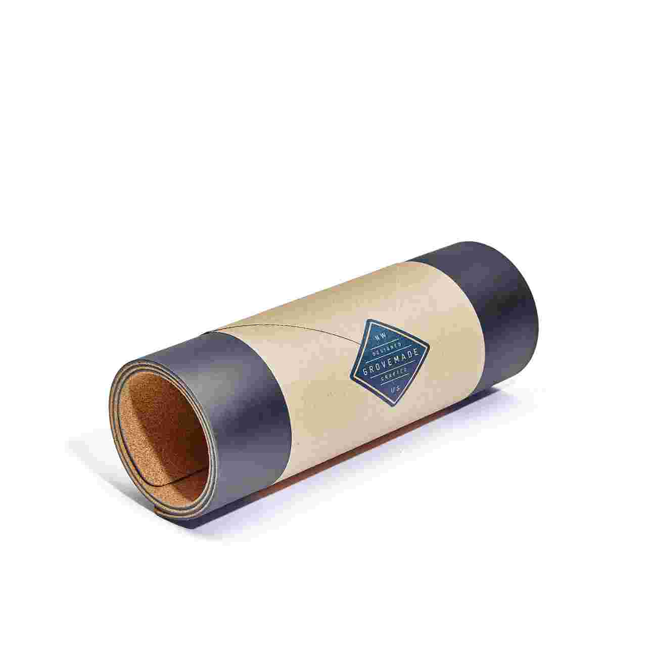 Medium Plus matte black desk pad, rolled in brown craft paper for easy gifting.