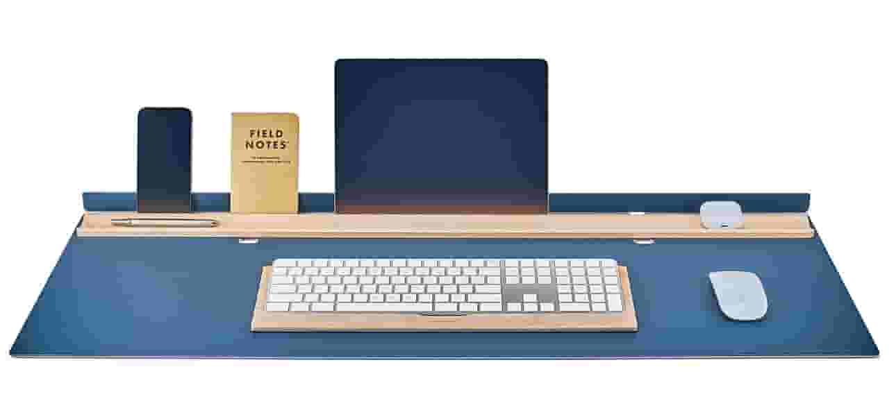 Matte navy desk pad with solid maple display rail.