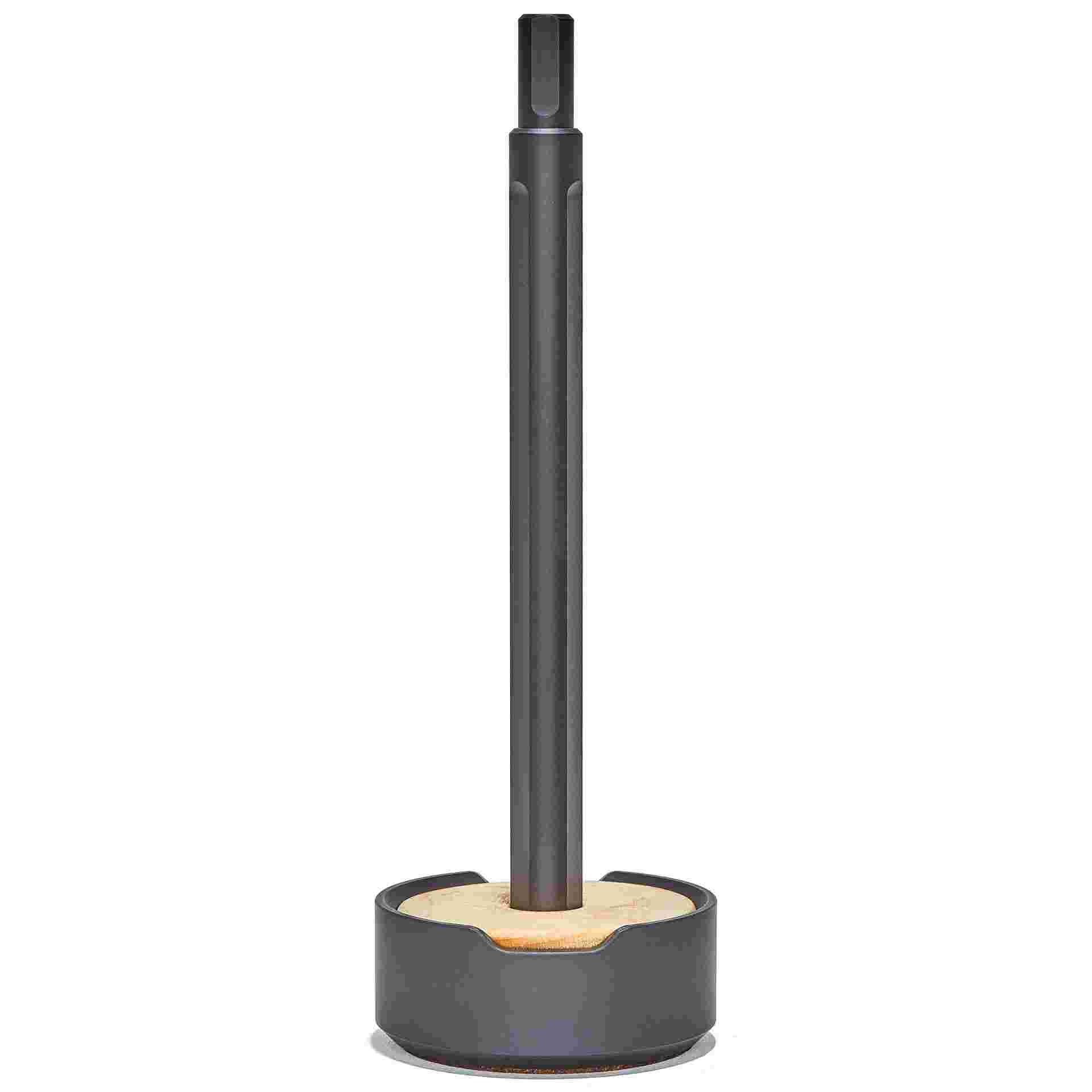 Starkly minimalist black pen set upright in maple wood and metal stand.
