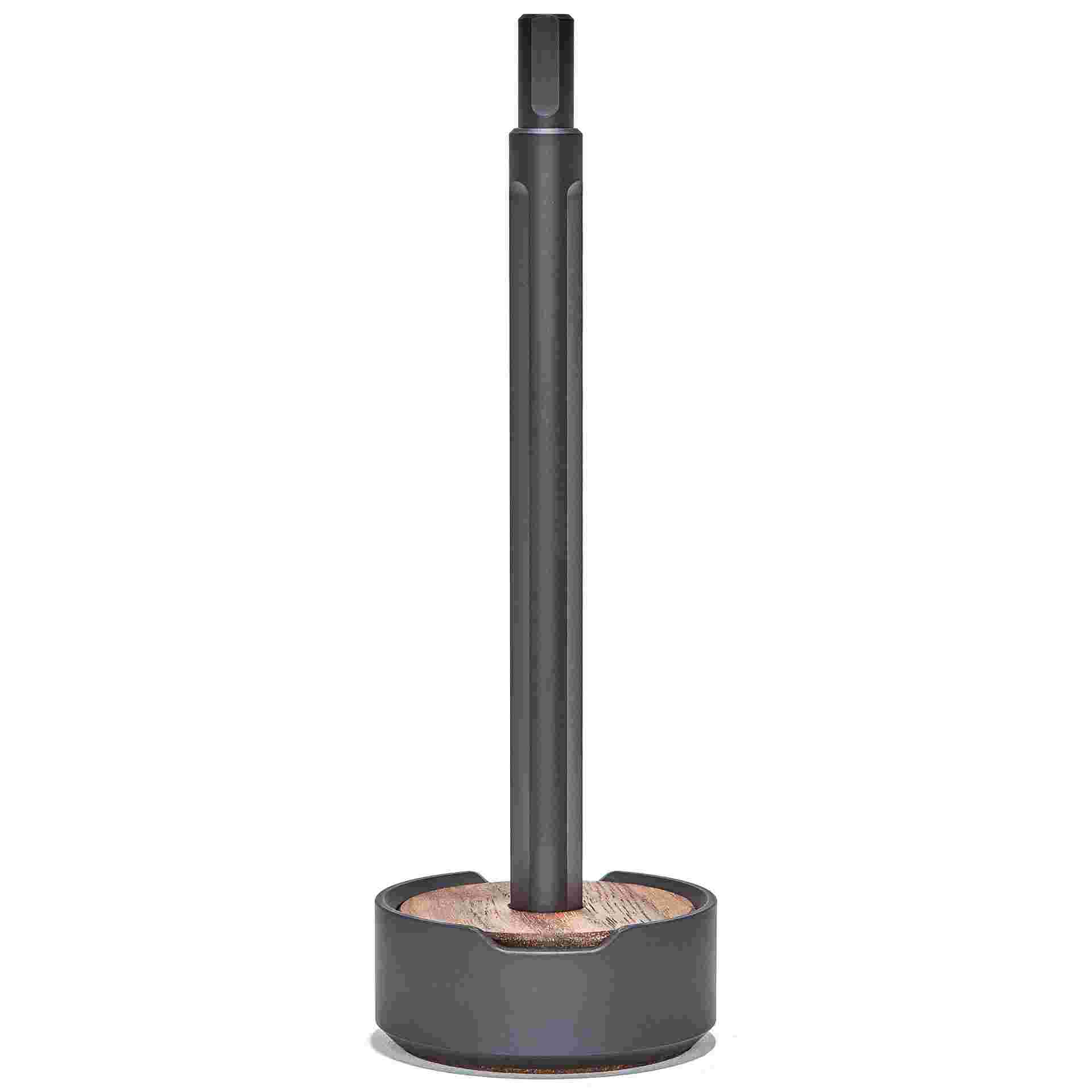 Starkly minimalist black pen set upright in walnut wood and metal stand.