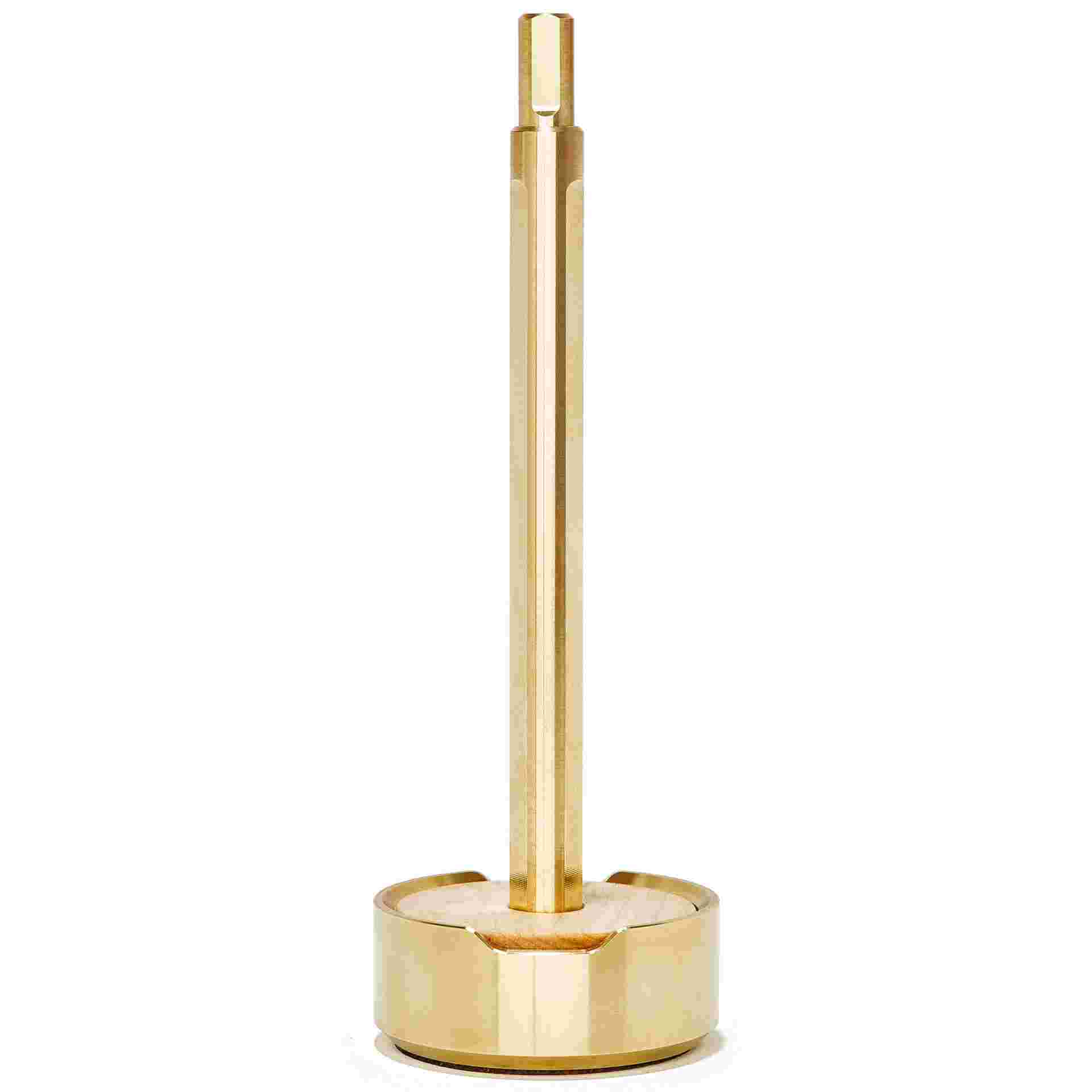 Starkly minimalist brass pen set upright in maple wood and brass stand.