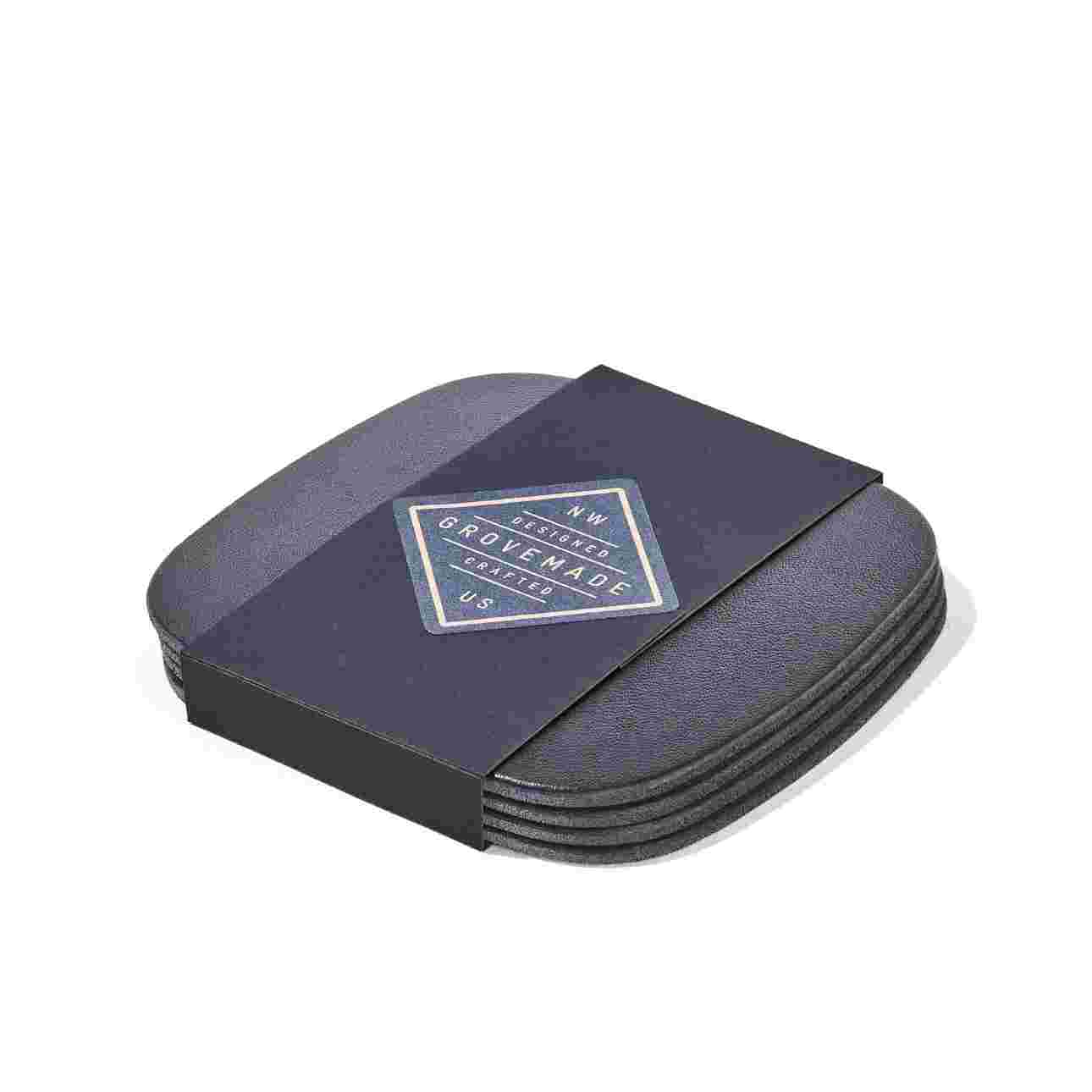 Set of four black leather coasters in black paper packaging.