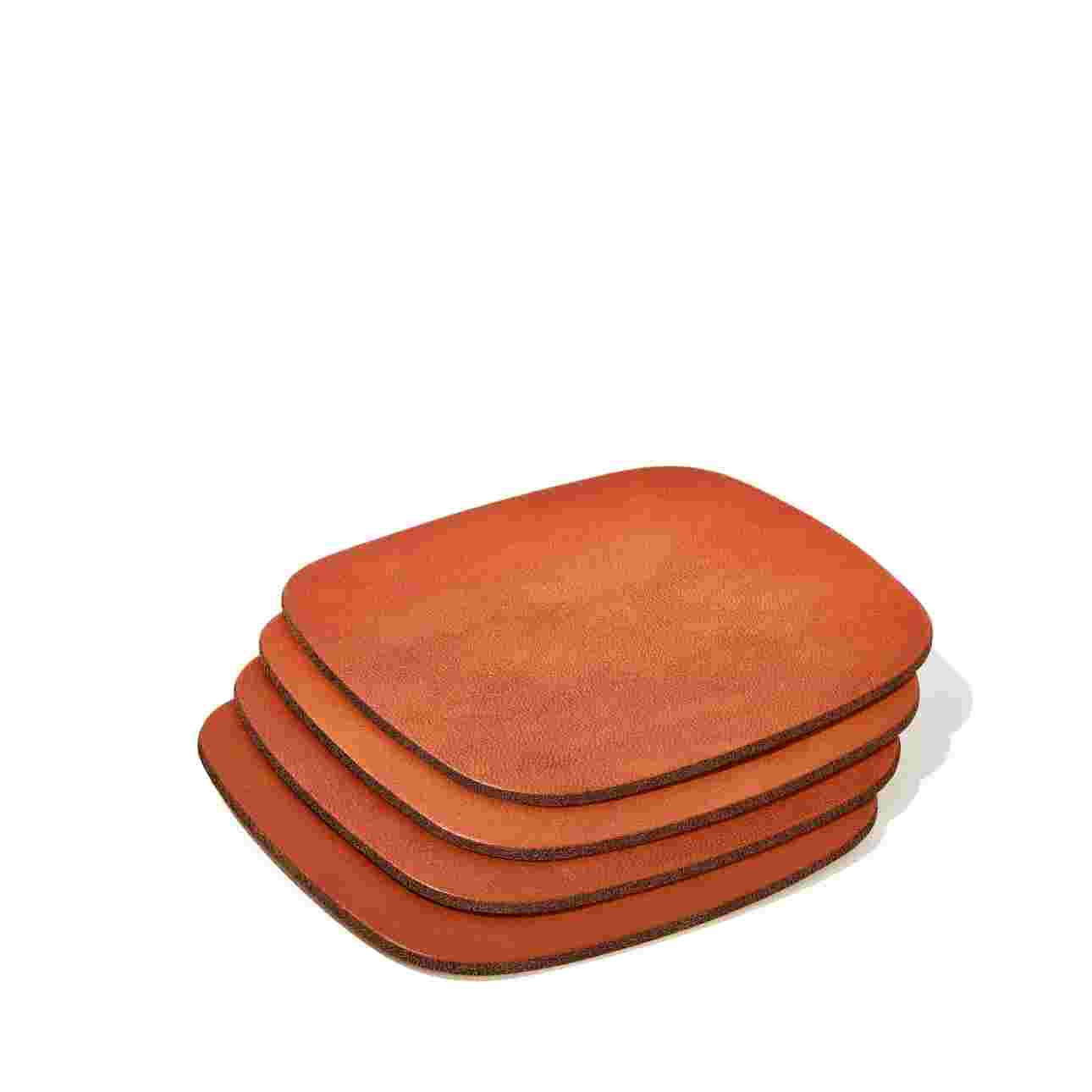Stack of four tan leather coasters.