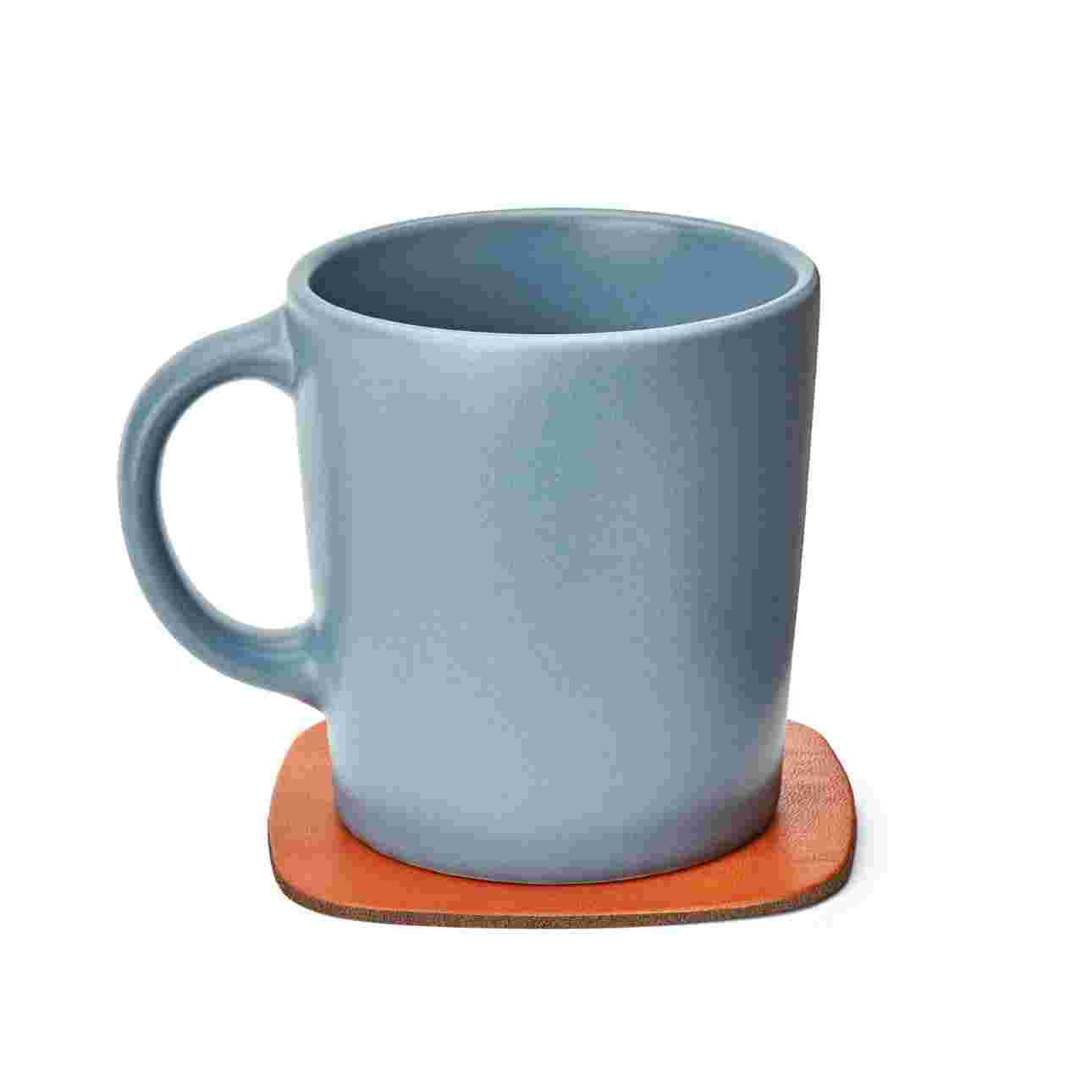 Tan leather coaster with gray coffee cup.