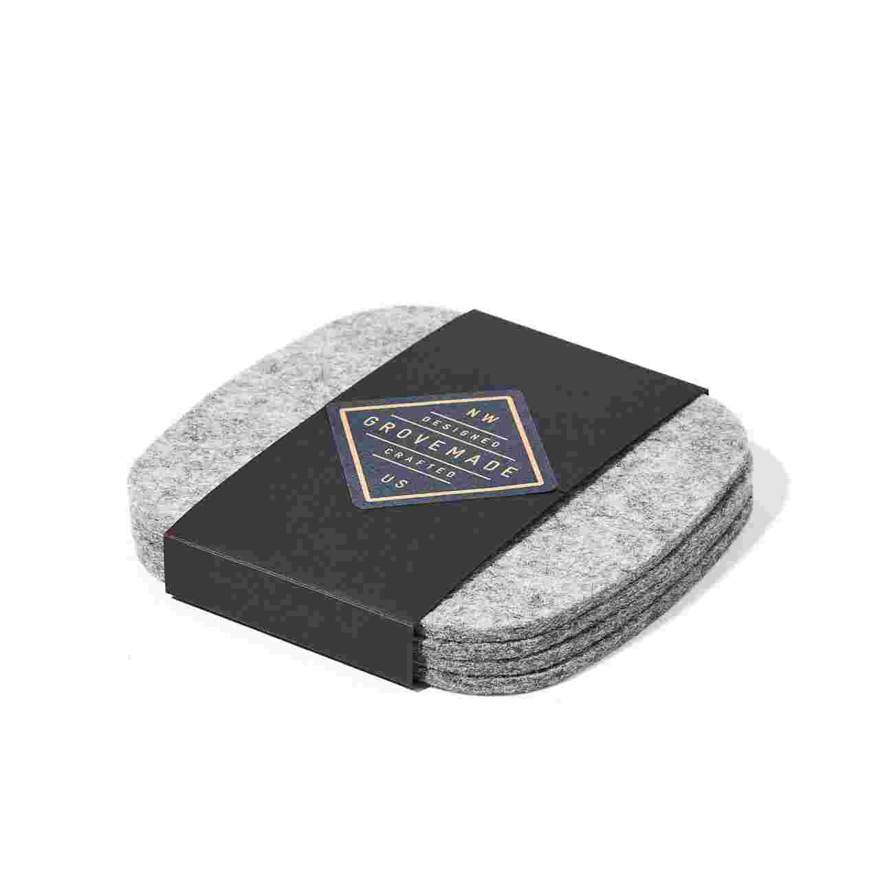 Light felt coaster set in black paper packaging.