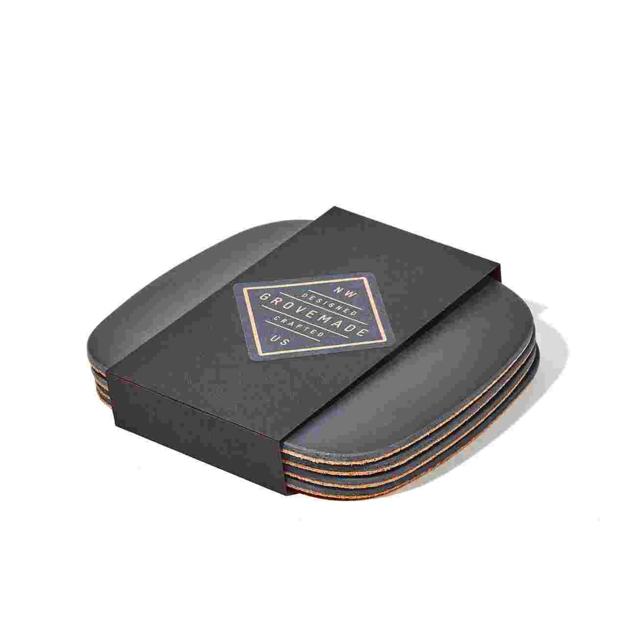 Set of four matte black coasters in black paper packaging.