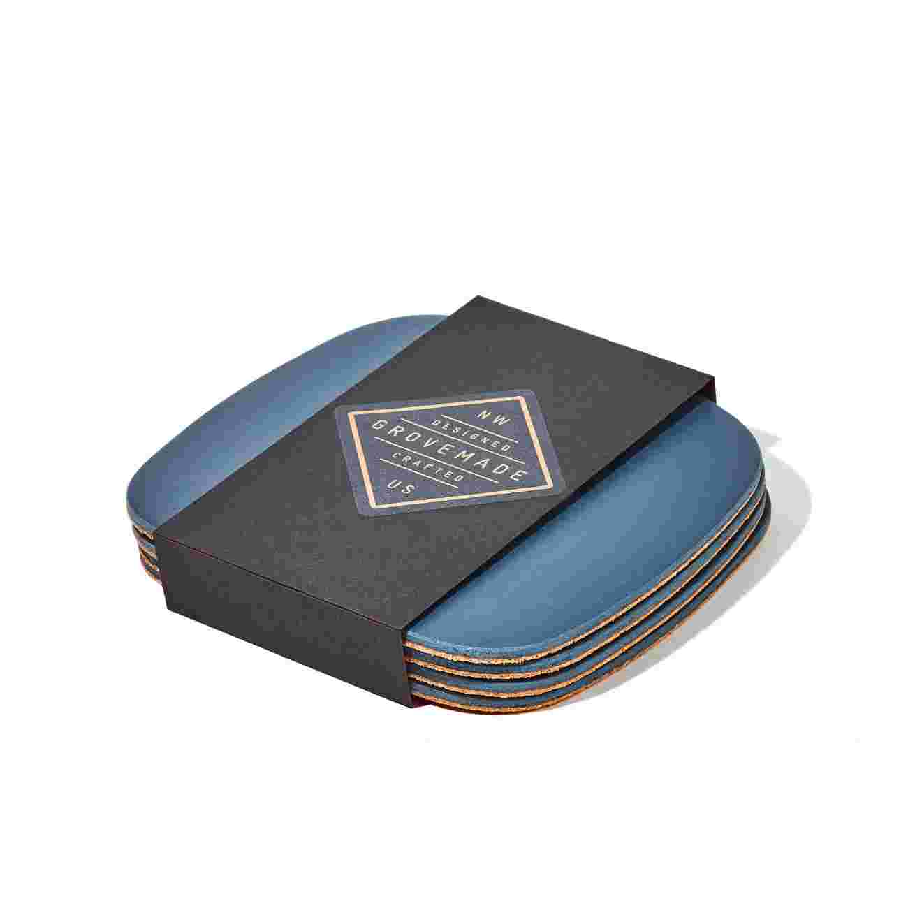 Set of four matte navy blue coasters in black paper packaging.
