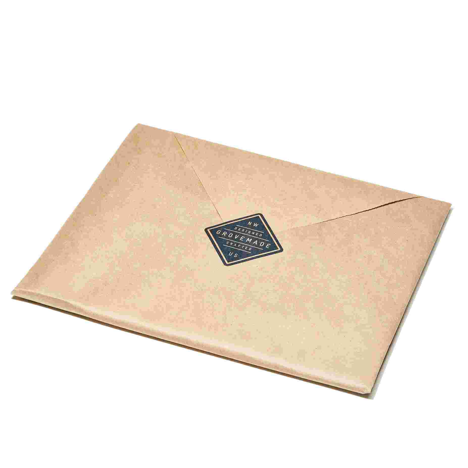 The Leather & Walnut Mouse Pad wrapped in brown craft paper.