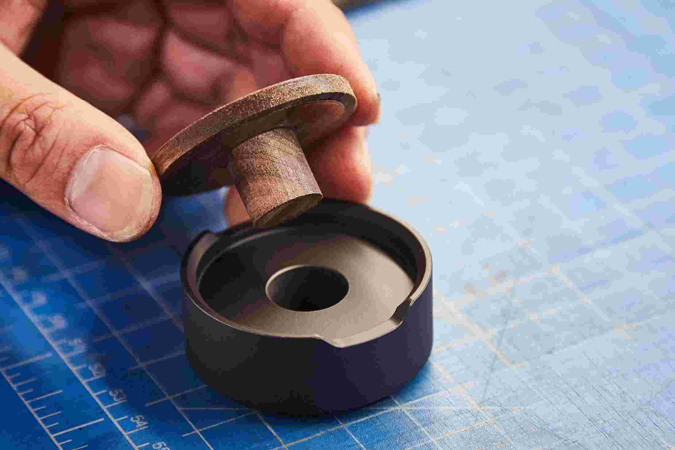 The wood element being inserted into the aluminum body. The pen stand is internally made of mostly metal, giving it a solid presence.