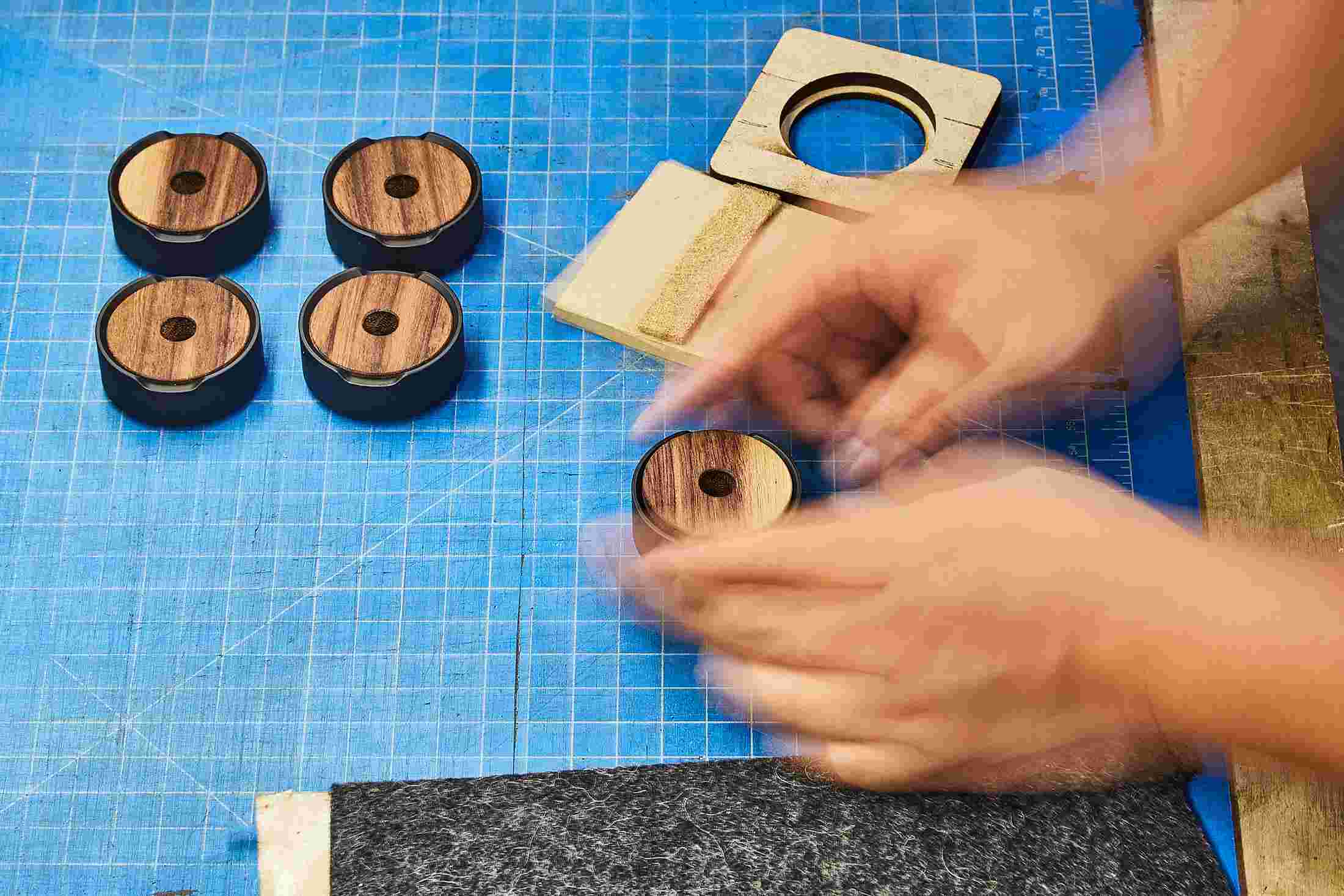 Black and walnut wood pen stands being assembled.
