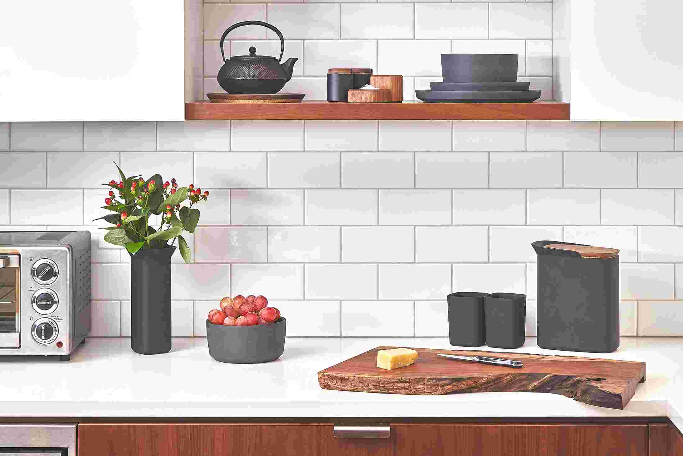 Walnut tableware collection pictured on kitchen shelves.