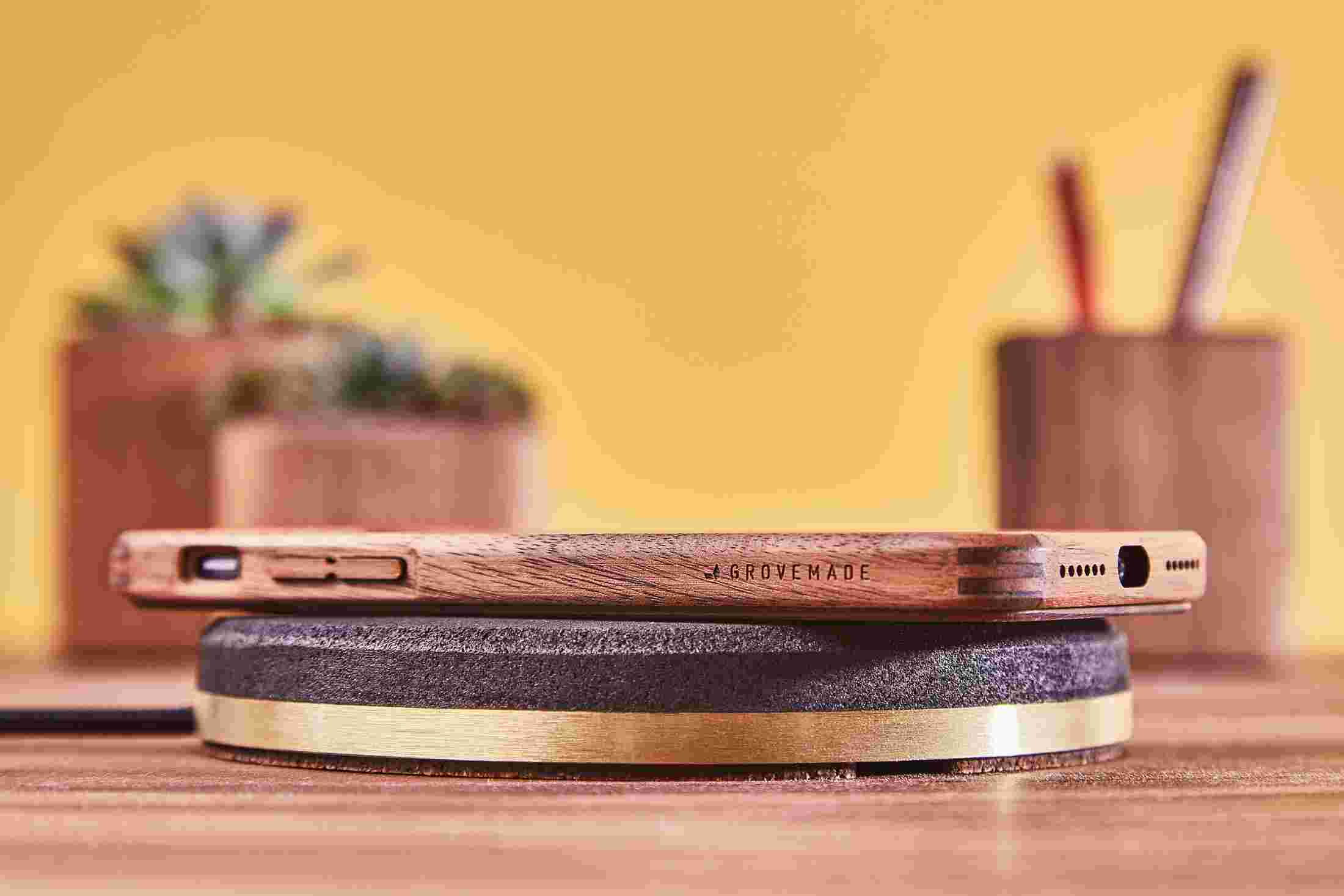 The Brass Wireless Charging Pad charging an iPhone X with Walnut Wood Case.