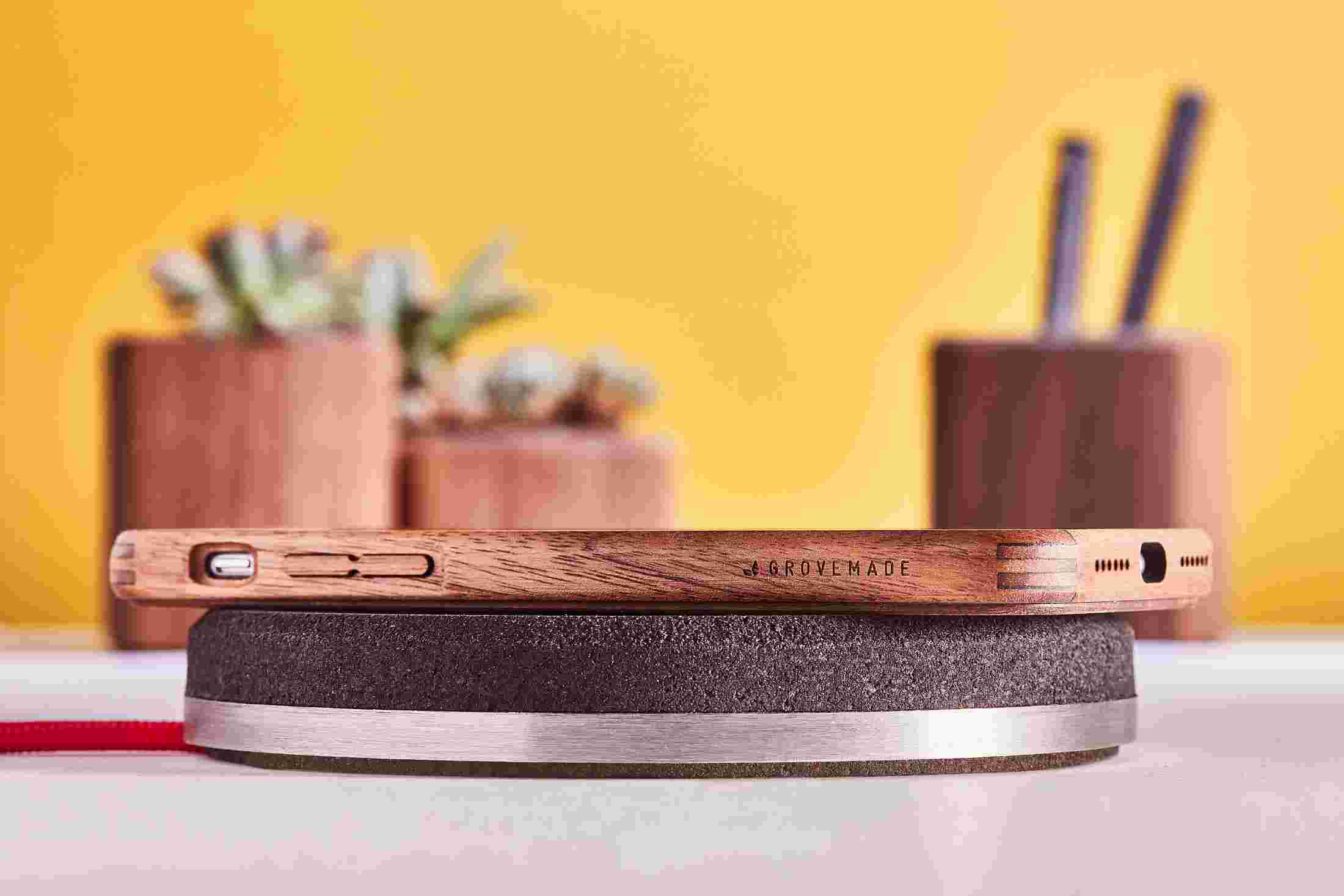 Profile view of the Wireless Charging Pad made of layered dark cork and a stainless steel base.
