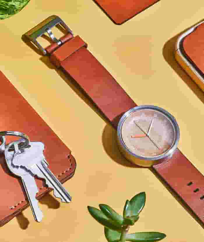 Wood and leather watch, phone case, and wallet, all in matching tan leather.