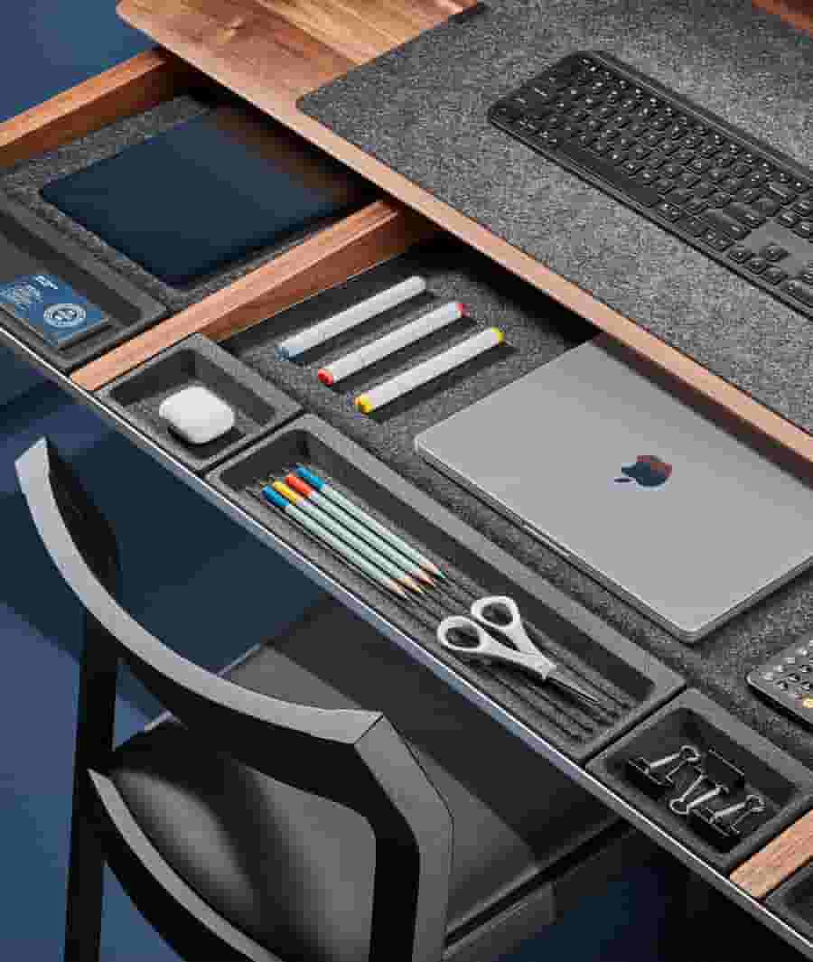 View inside the full width drawer of the walnut desk with divided sections and cork organizers.