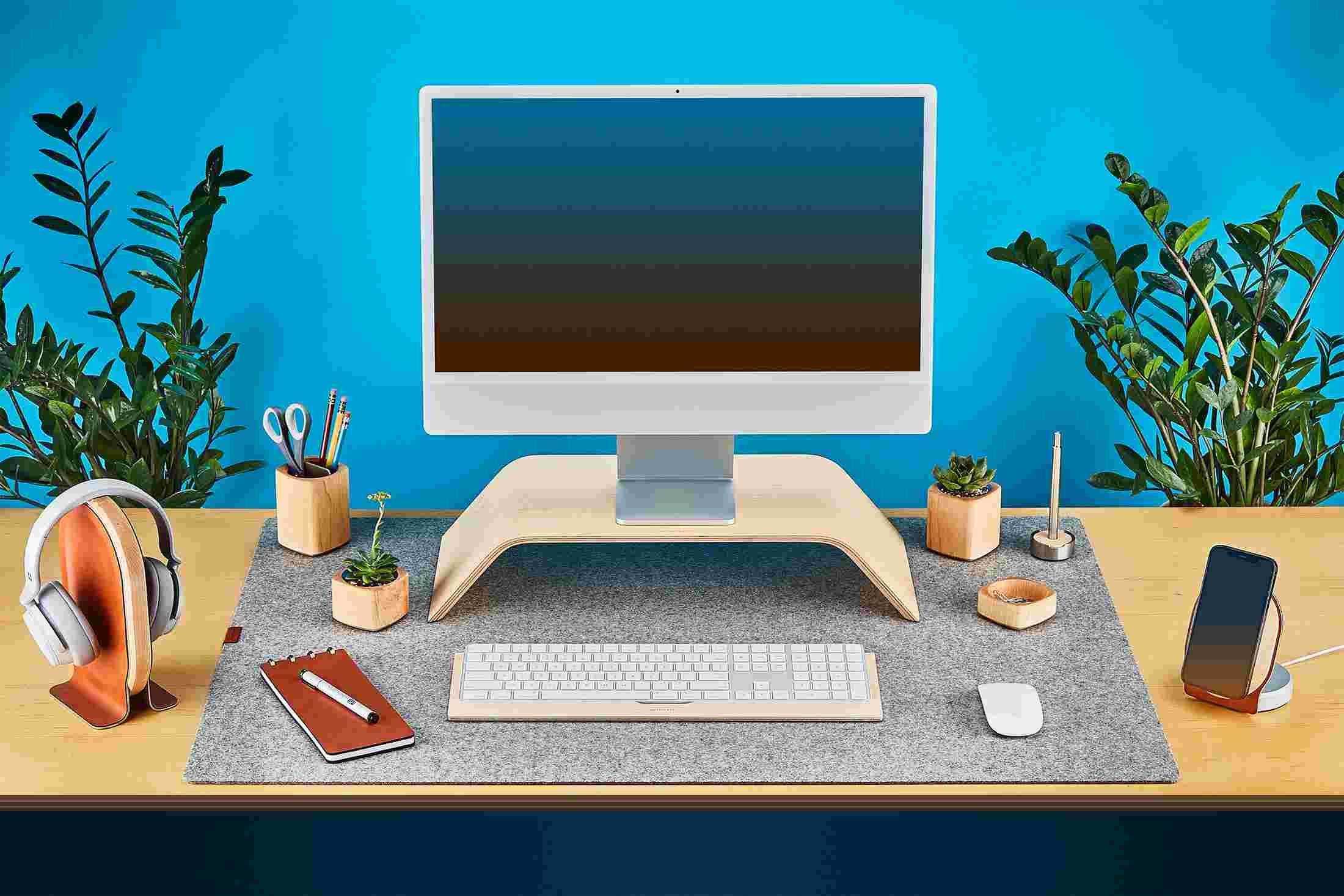 The Grovemade Maple Wood Desk Collection featuring bent wood monitor stand, wool felt desk pad, and wood headphone stand.