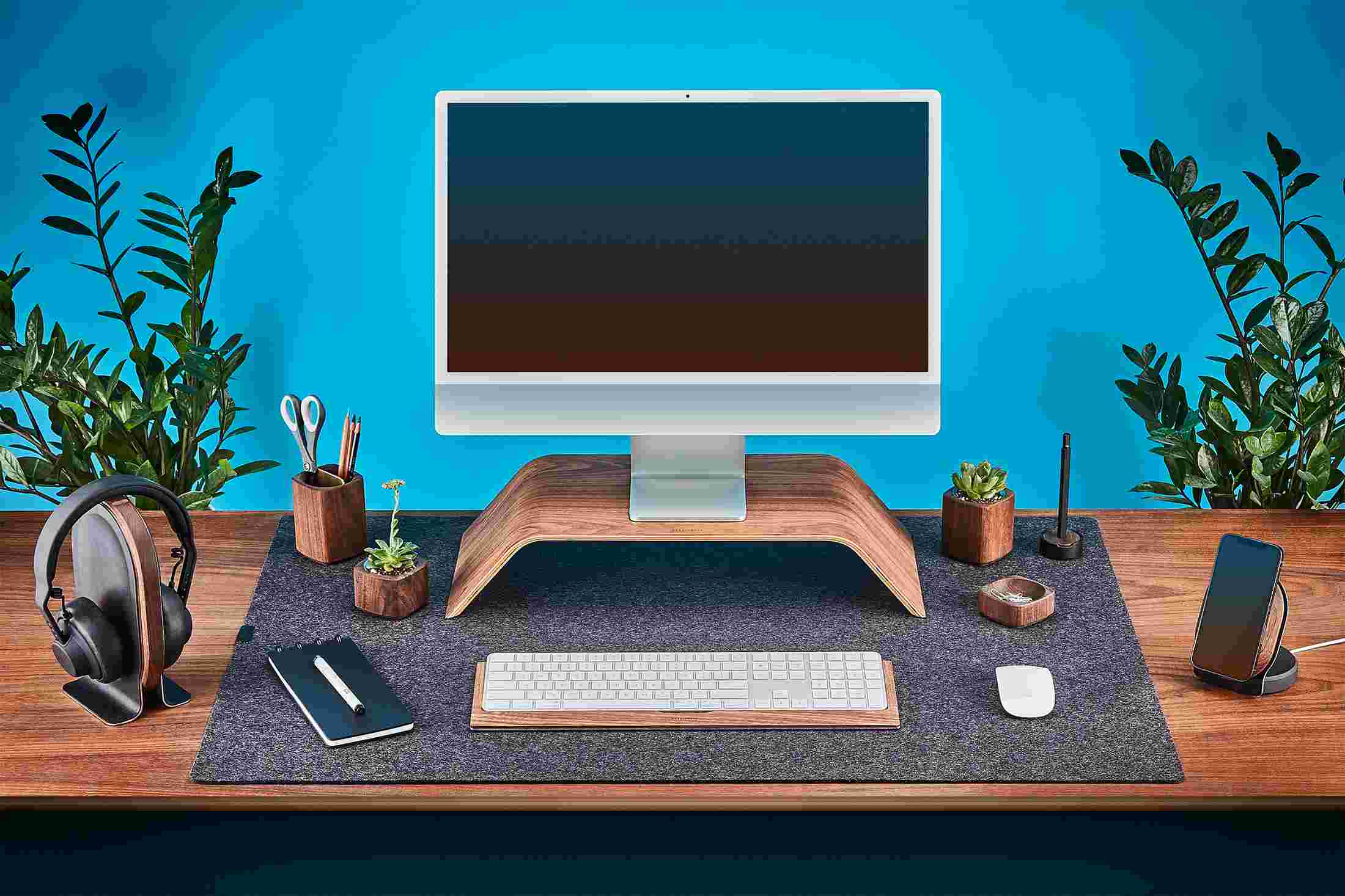 The Grovemade Walnut Desk Collection, featuring bent wood iMac stand, wood keyboard tray, leather headphone stand, and MagSafe Charging Dock.