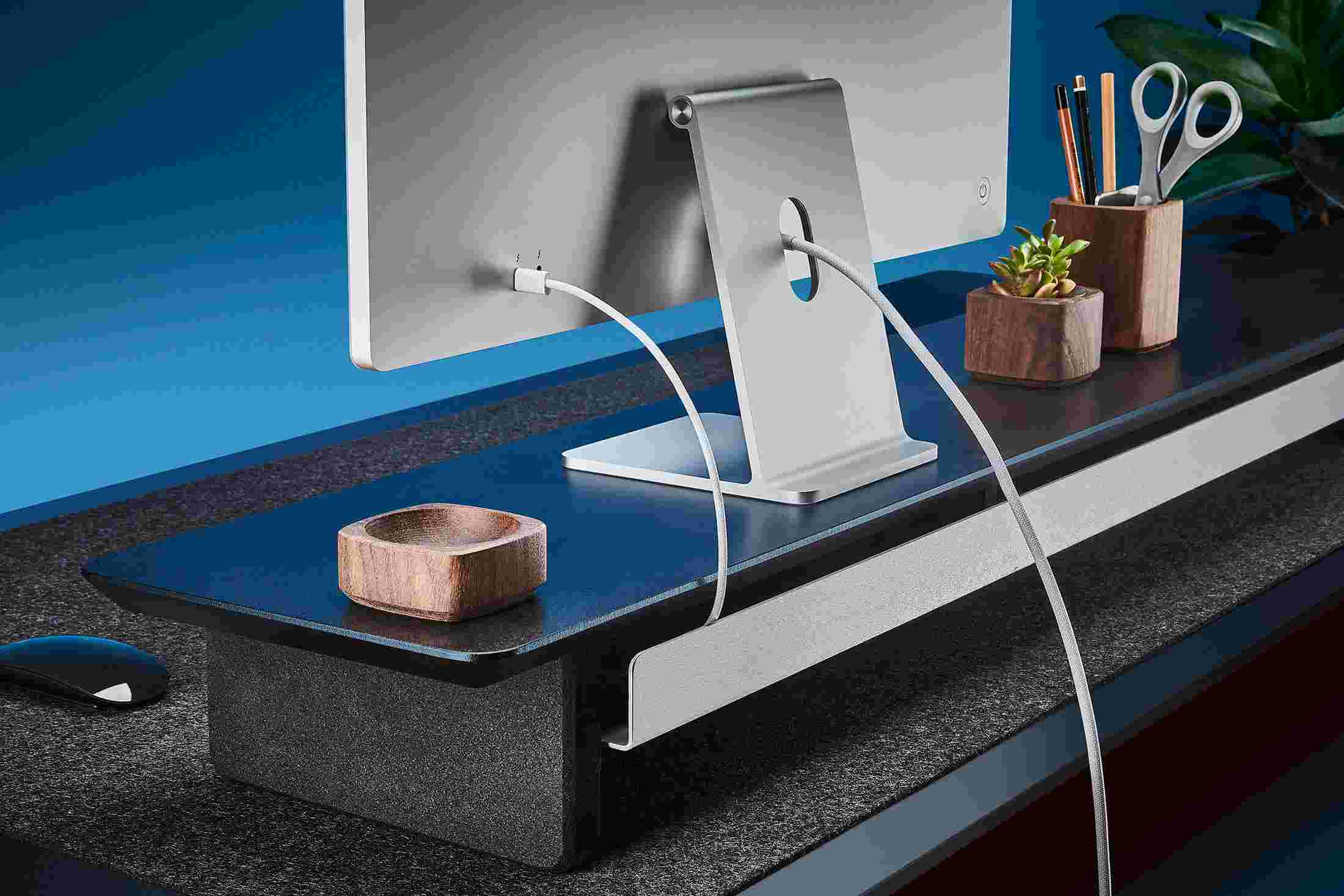 Rear view of the walnut shelf showing the back edge of the bent metal shelf, designed to keep your stuff in place, while leaving space for hidden cord access.