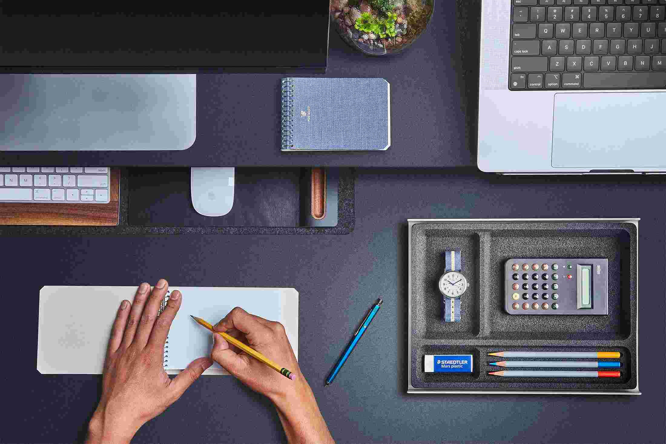 Overhead of the small desk pad with keyboard and mouse slid under the desk shelf to free up desk space.