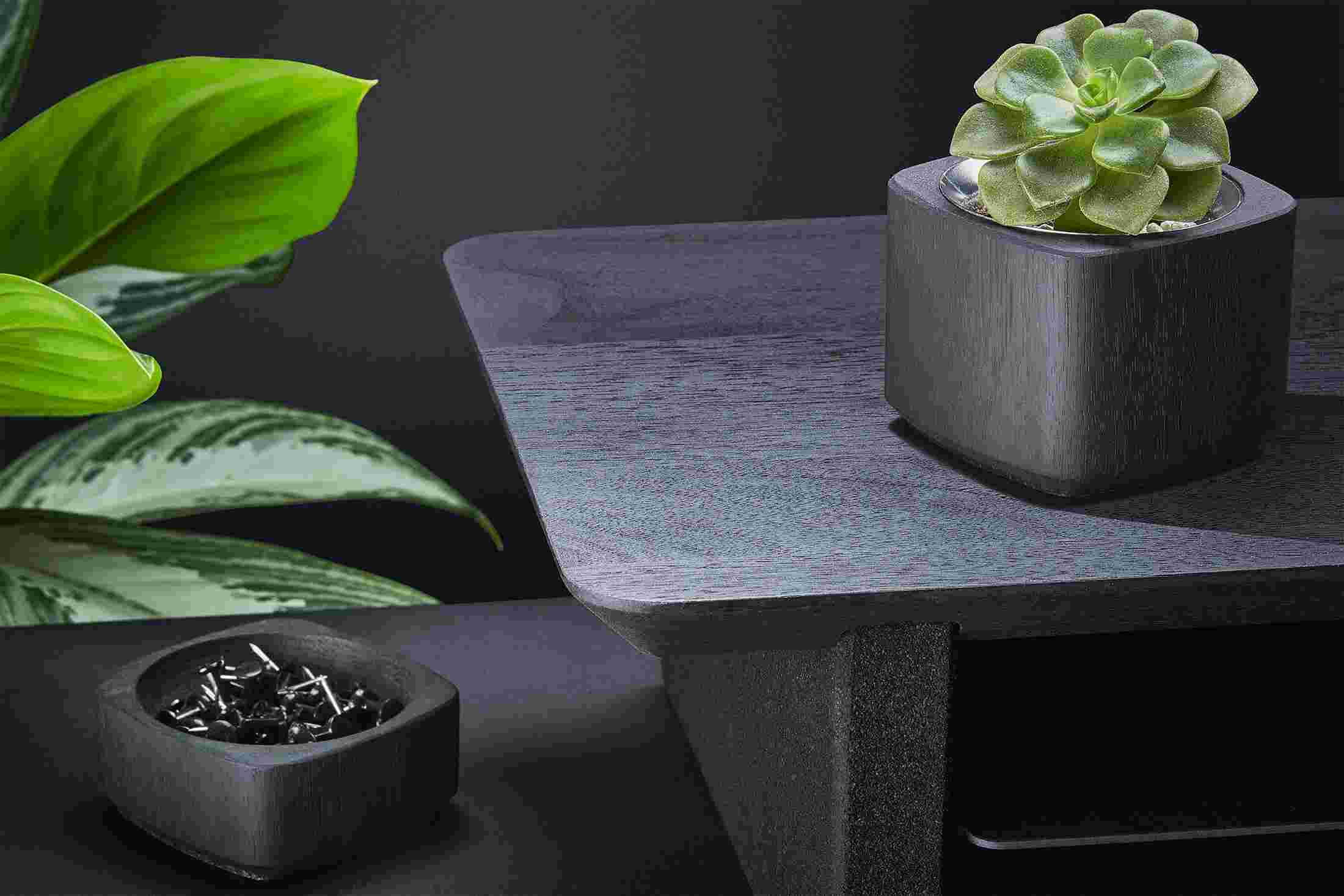 Material detail of the blackened walnut surface—the wood is stained black but the natural grain still shines.