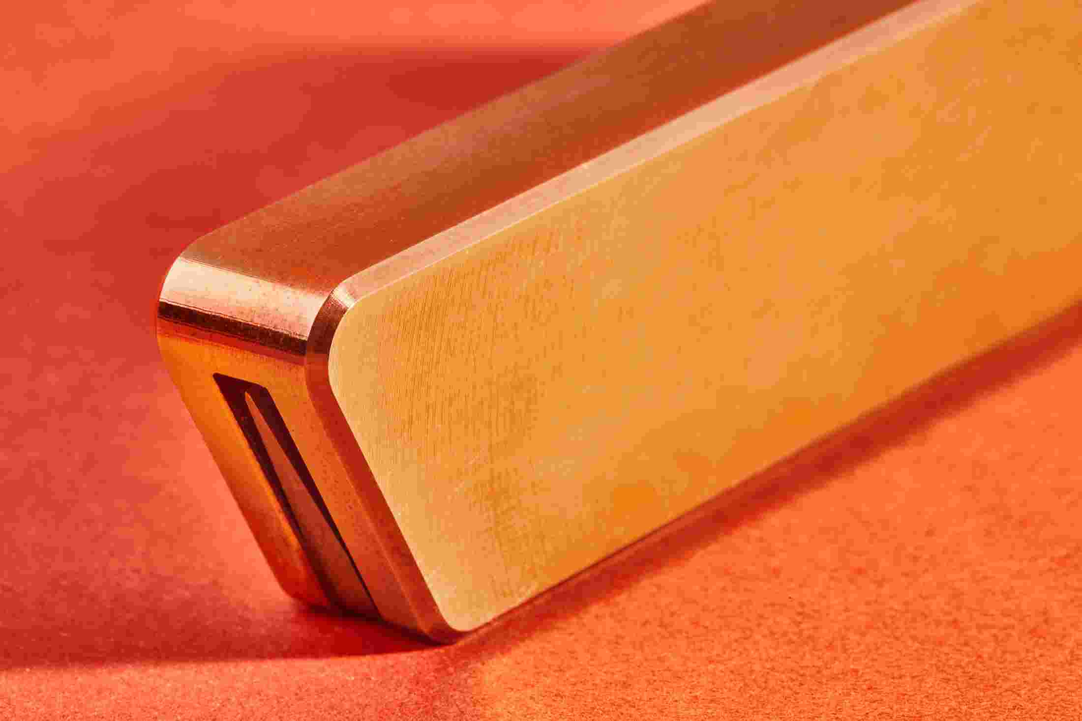 Close up detail of one-piece machined steel folding pocket knife with brass handle.