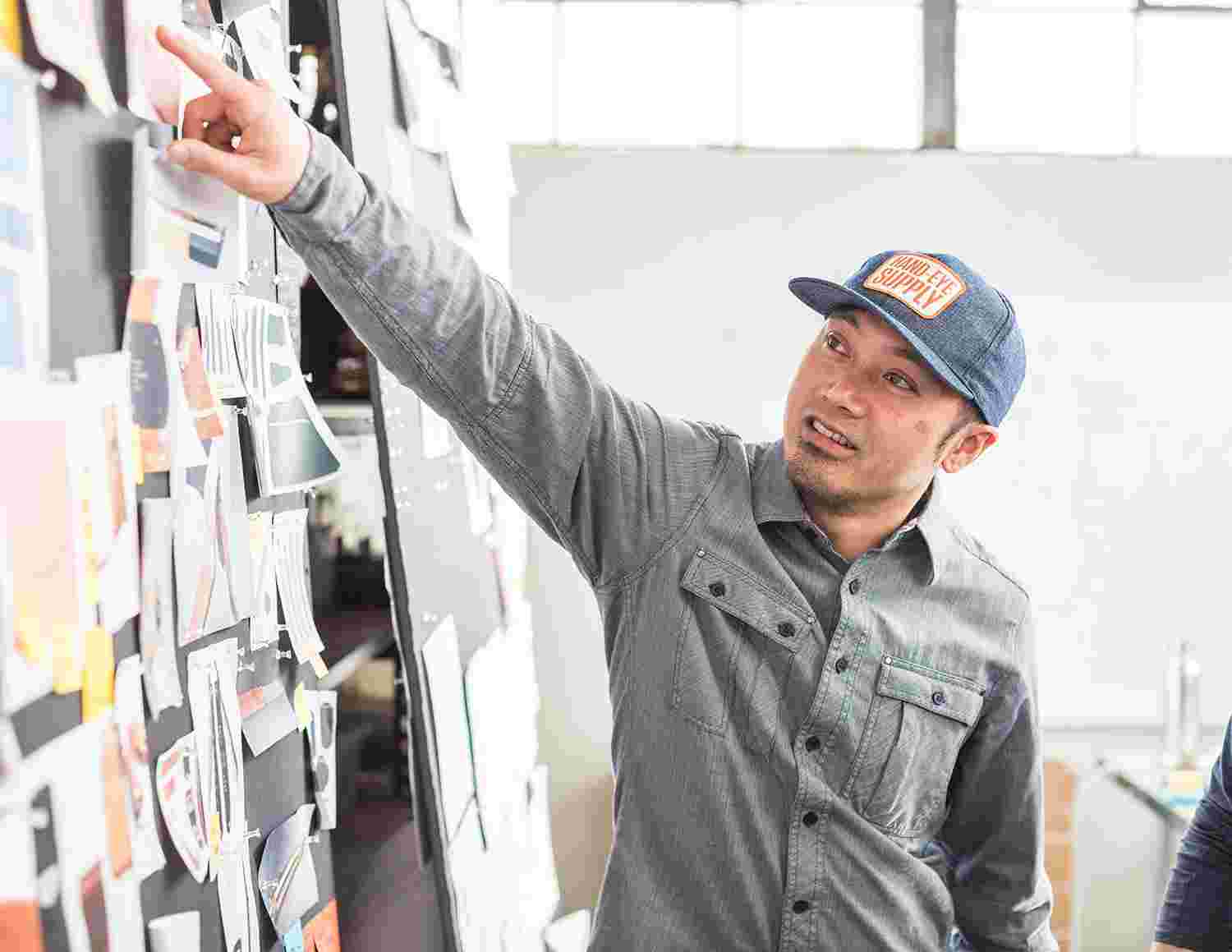 Ken pointing to an item on a design concept board.