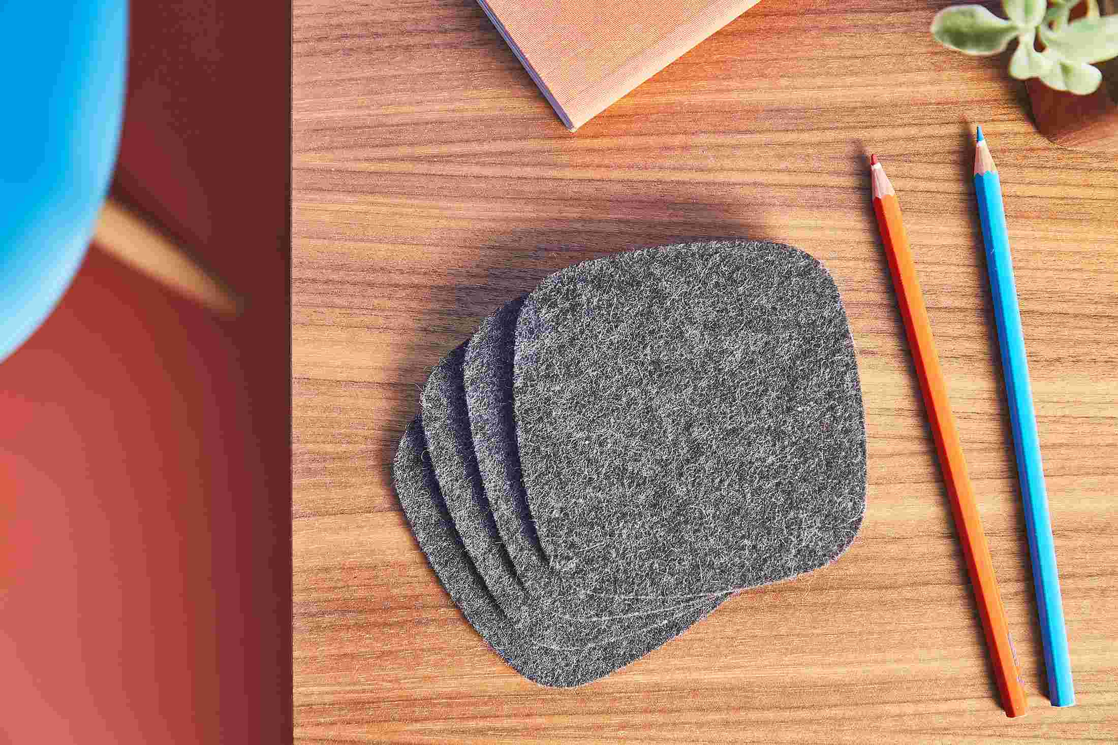 Overhead shot of a set of four premium dark wool felt coasters.