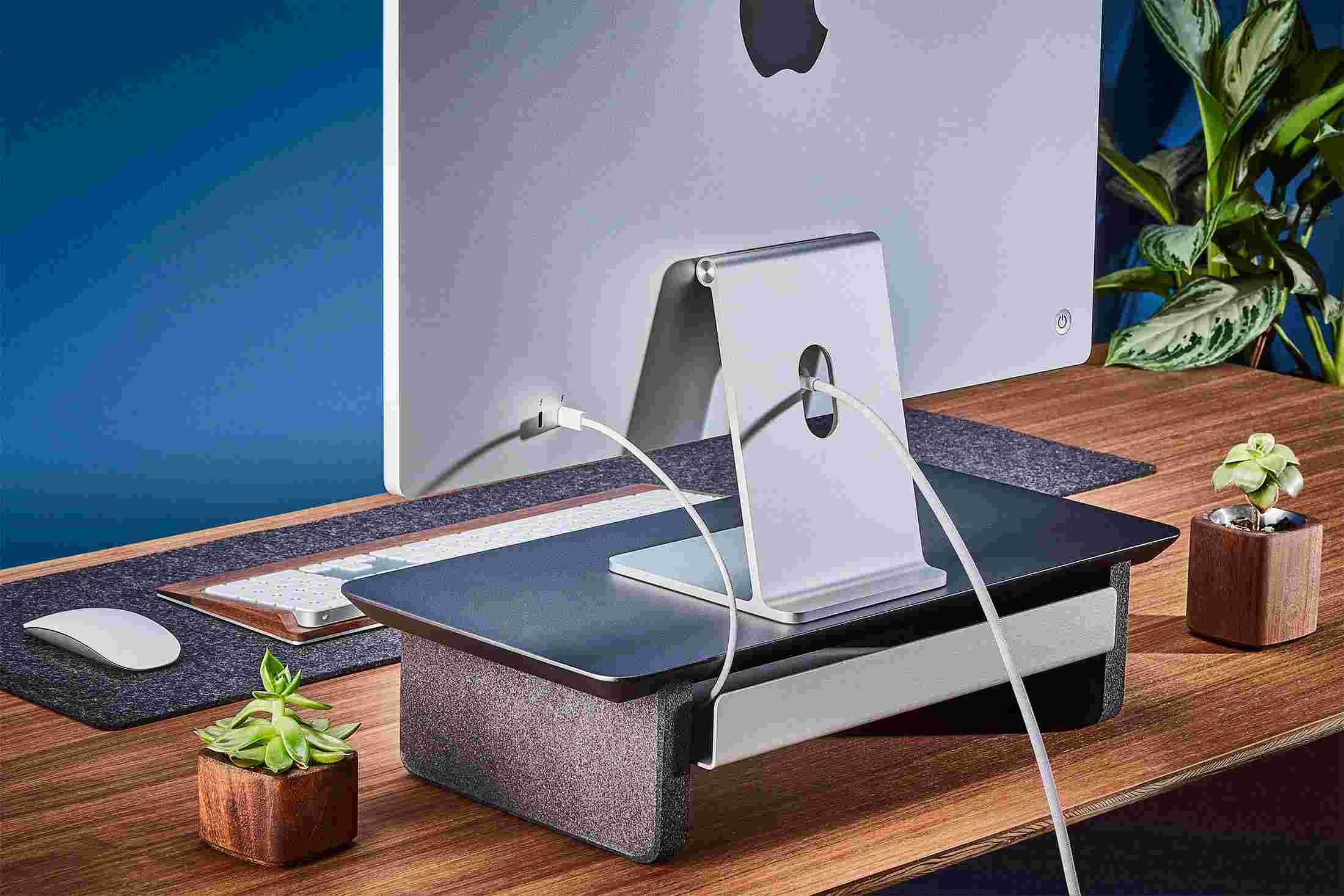 Rear view of the small matte black monitor organizer showing the back edge of the bent metal shelf, designed to keep your stuff in place, while leaving space for hidden cord access.