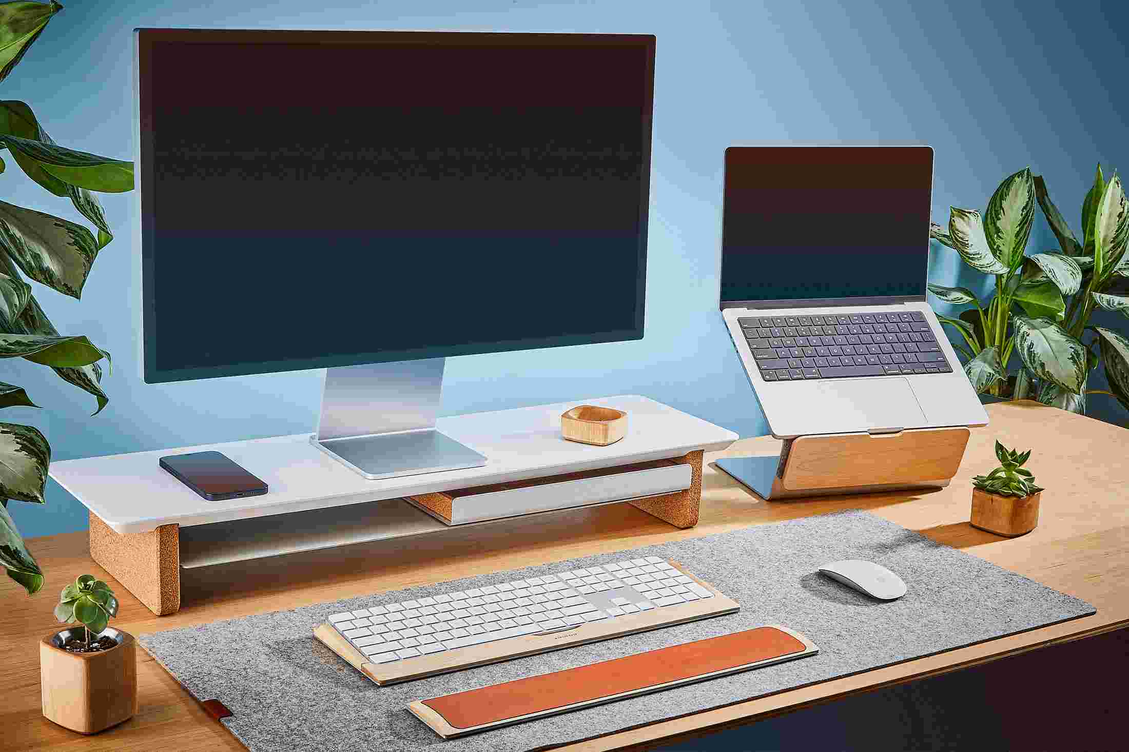 The medium Matte White Desk Shelf and Laptop Riser, paired with medium light grey wool felt desk pad.