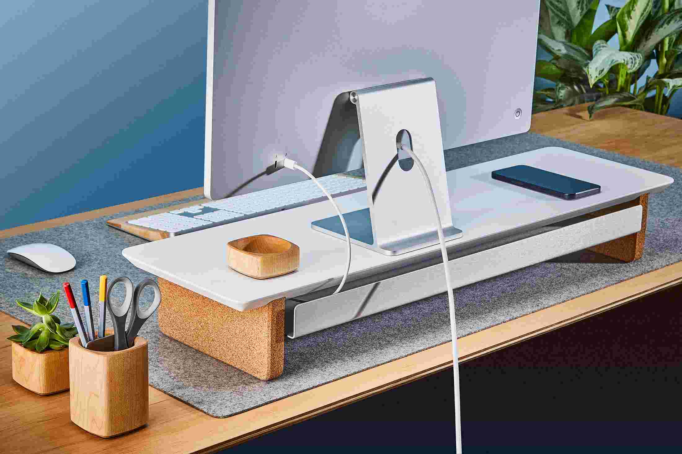 Rear view of the medium matte white monitor organizer showing the back edge of the bent metal shelf, designed to keep your stuff in place, while leaving space for hidden cord access.