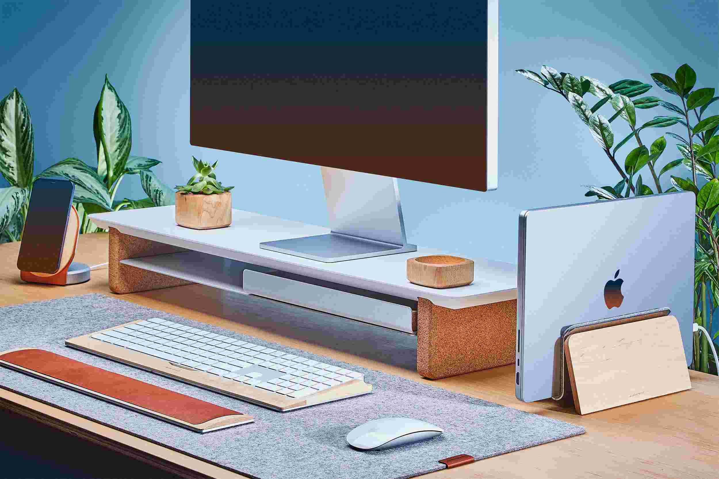 Space saving vertical MacBook Dock and medium matte white monitor stand, with desk pad.