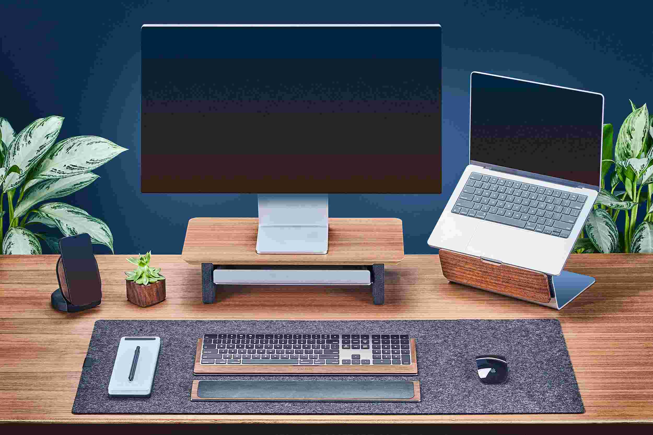 Small Walnut Monitor Stand with Apple Studio Display and matching walnut laptop stand for MacBook.