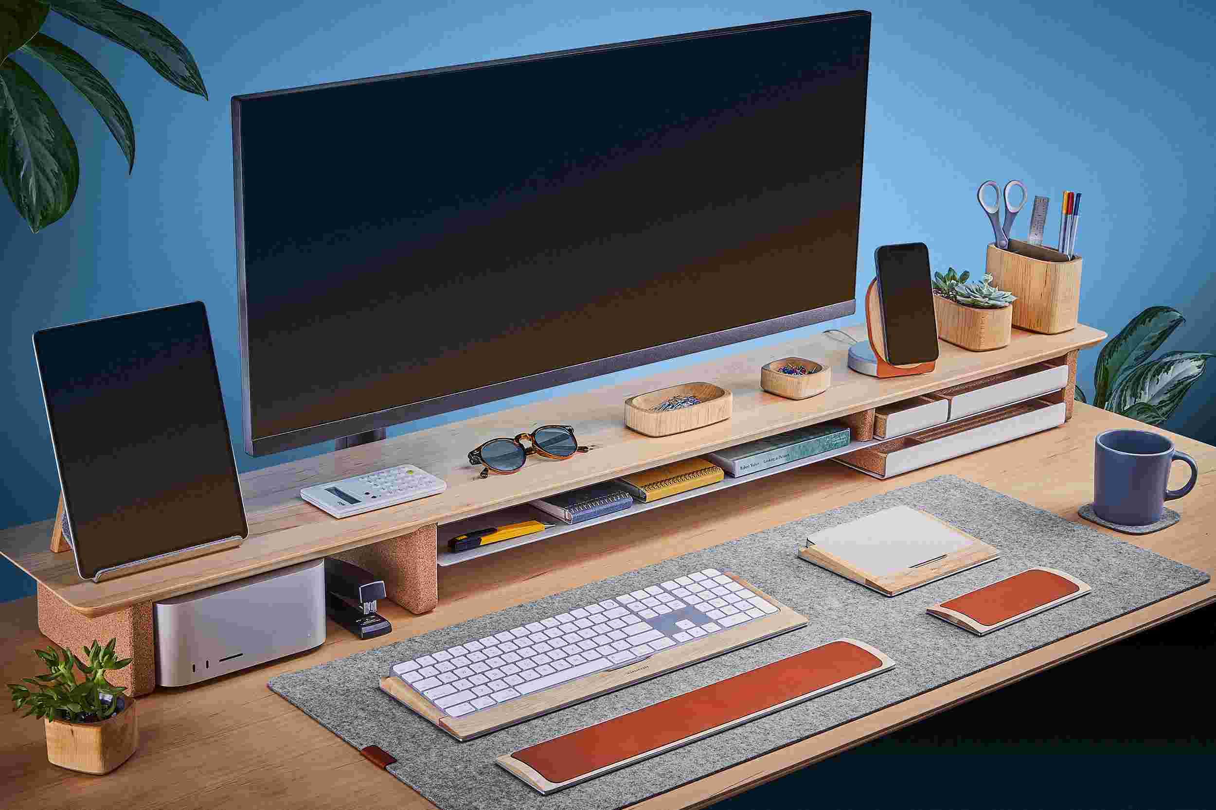Ultra-wide solid maple desk shelf for double monitor setup, with light merino wool felt desk pad.