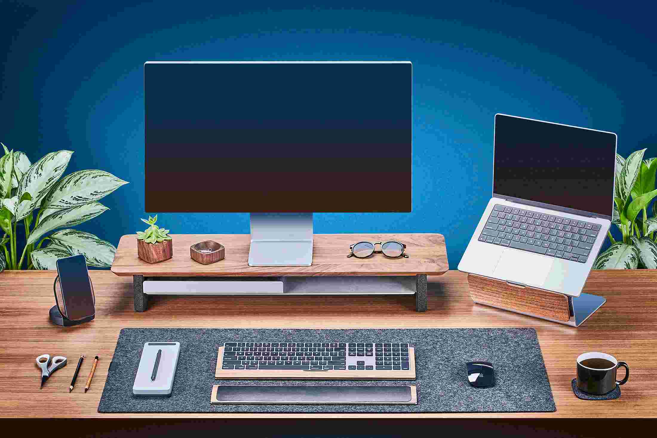 Medium Solid Hardwood Walnut Monitor Stand with Apple Studio Display and matching walnut laptop stand for MacBook.