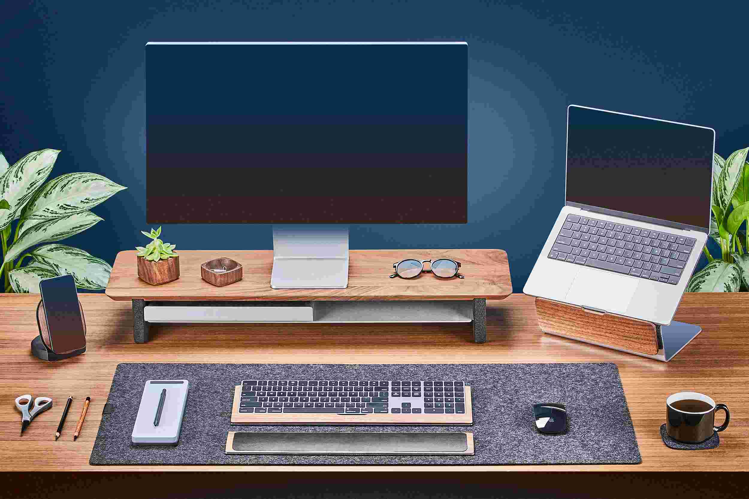 Medium Solid Hardwood Walnut Monitor Stand with Apple Studio Display and matching walnut laptop stand for MacBook.