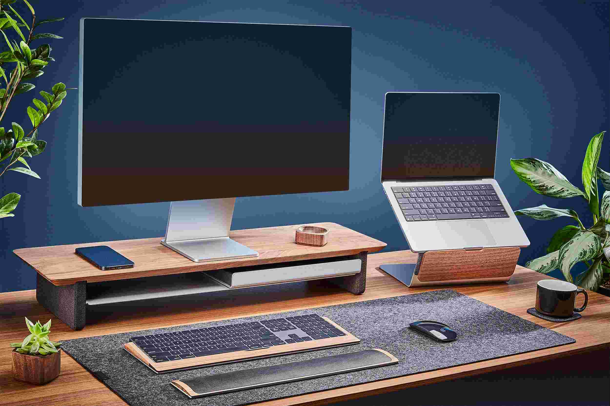 The medium solid hardwood Walnut Desk Shelf and Laptop Riser, paired with medium dark grey wool felt desk pad.