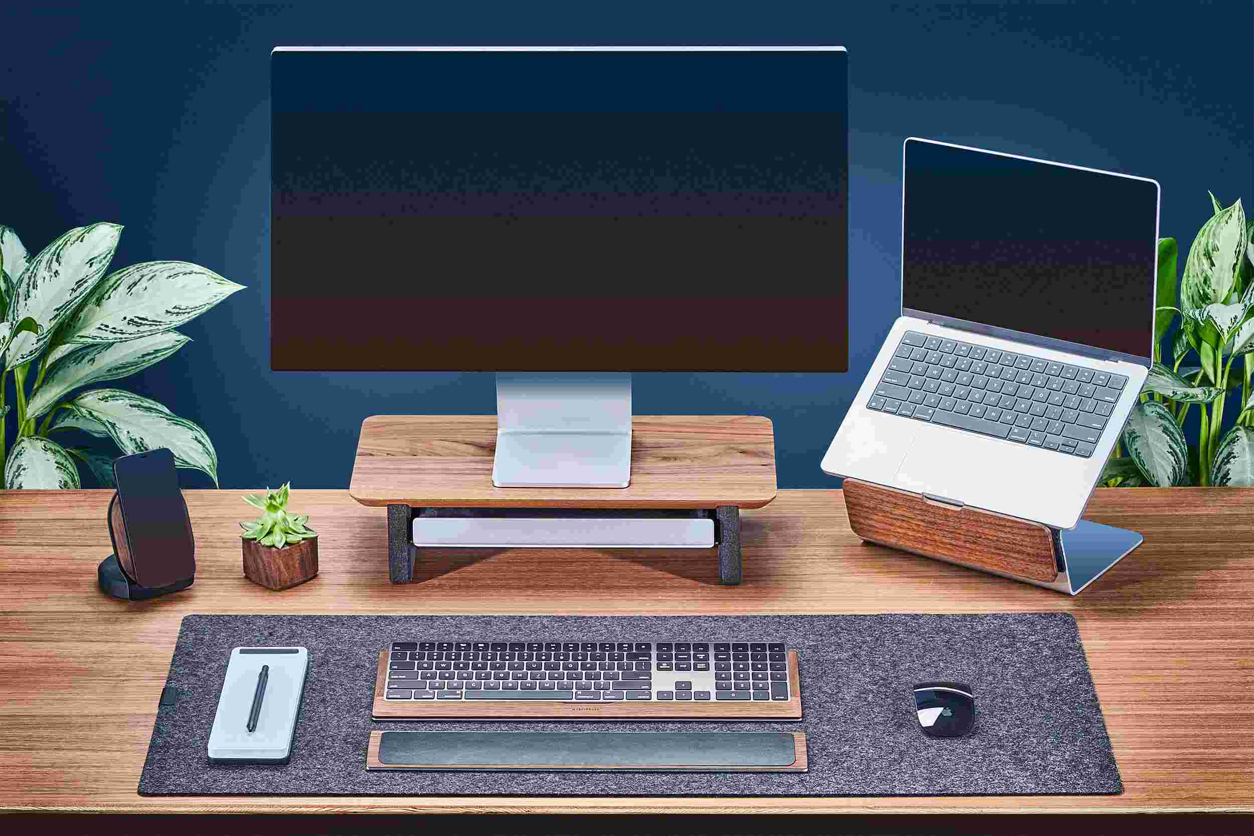 Small Walnut Monitor Stand with Apple Studio Display and matching walnut laptop stand for MacBook.