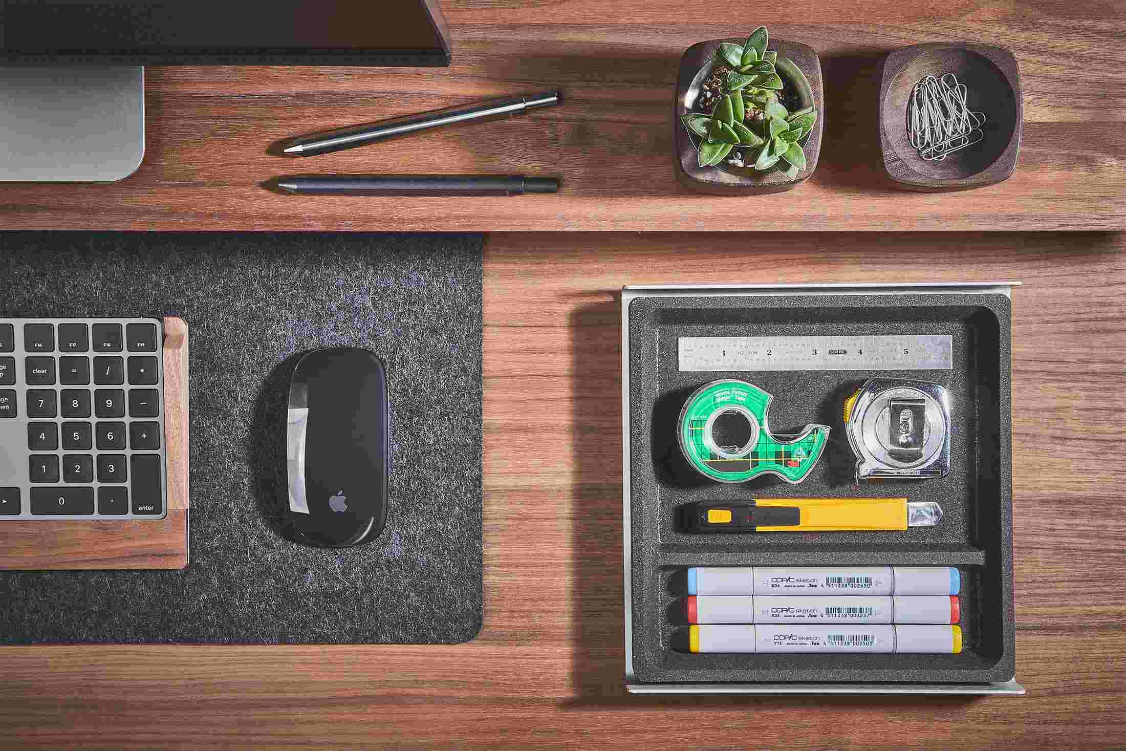 Overhead view of the medium dark cork desk tray holding office supplies.