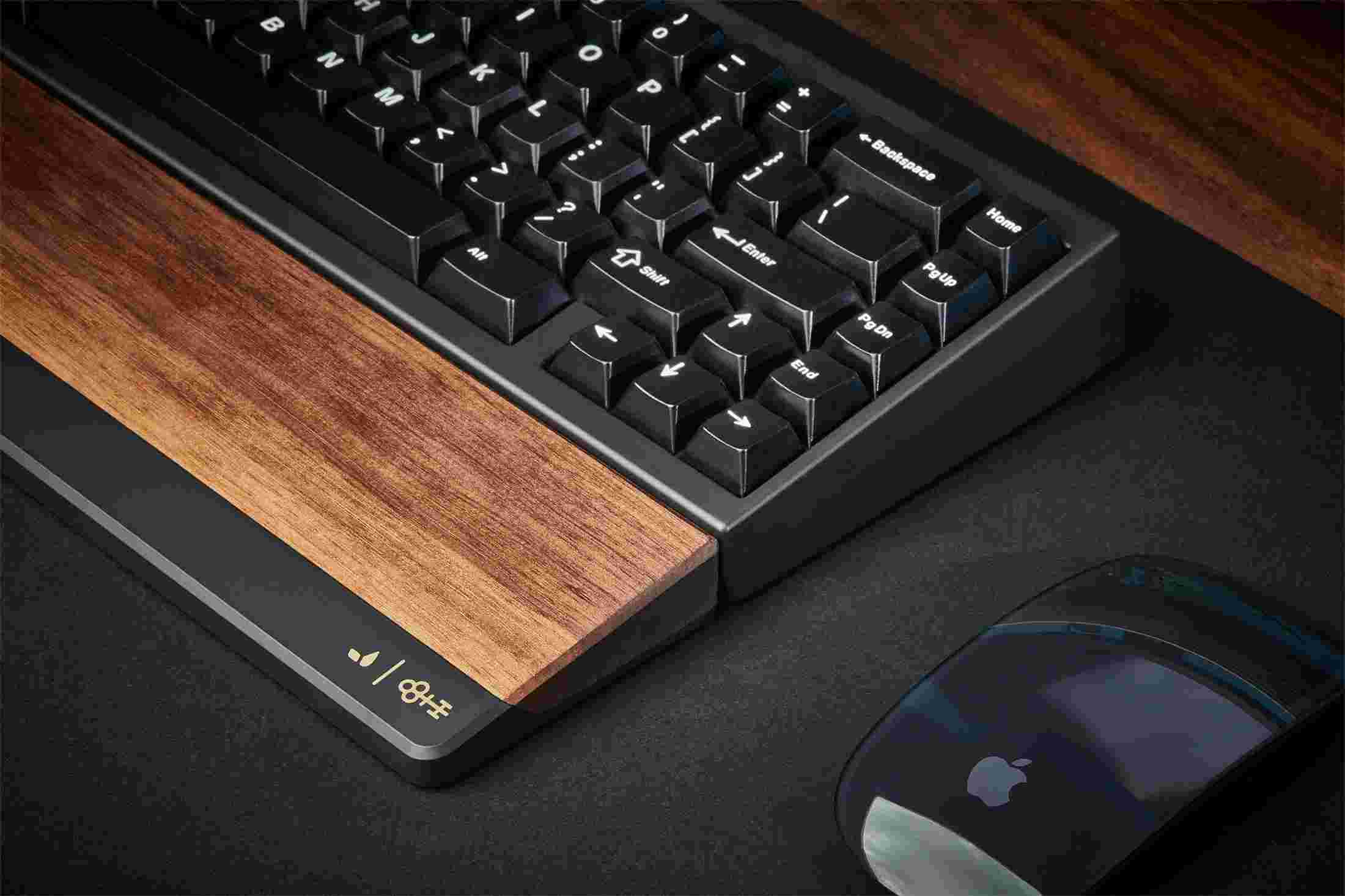 Detail of the laser etched logo marks on the machined metal rim of the walnut wrist rest.
