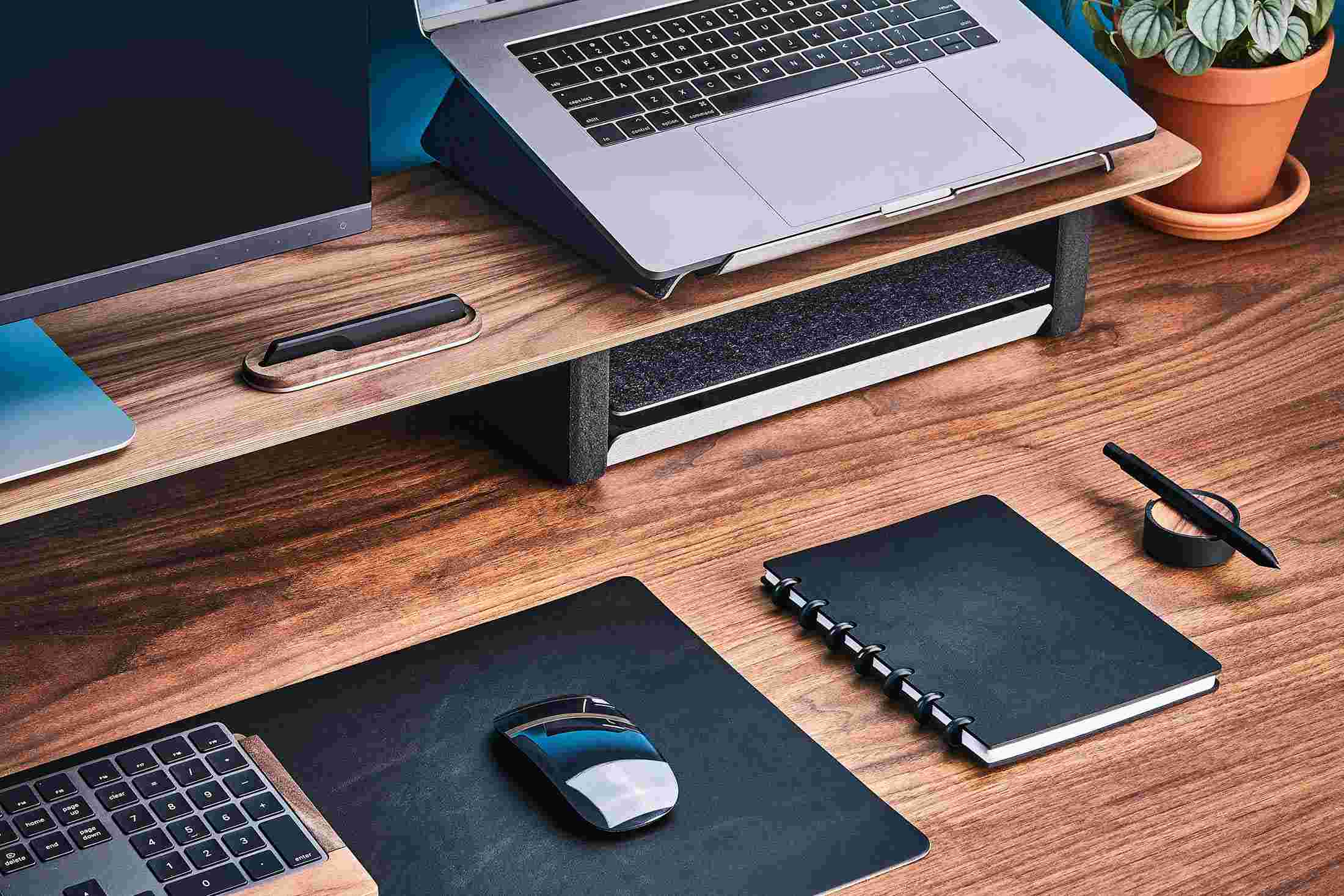 Black leather discbound notebook on walnut desk with matching leather desk pad.