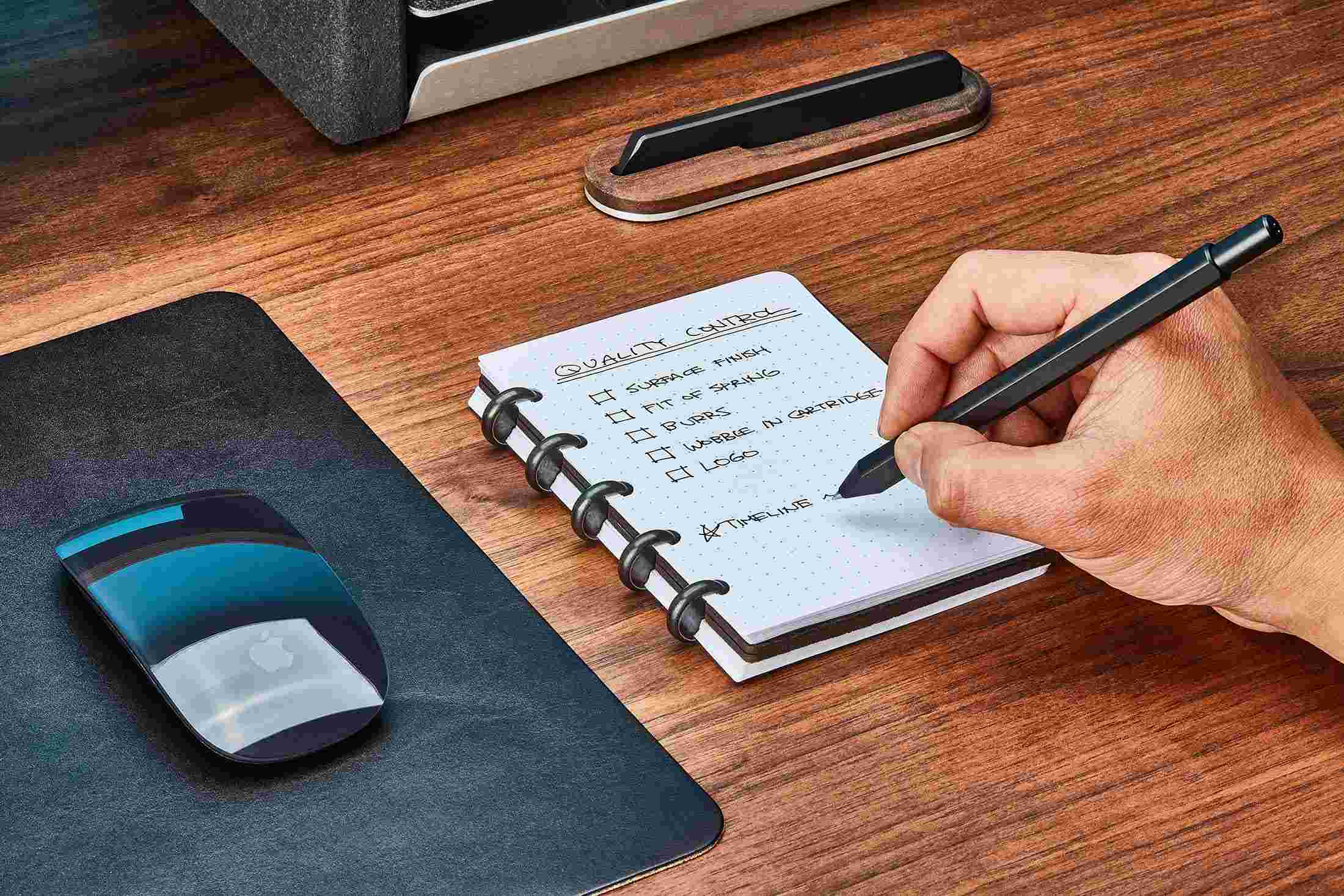 Black leather discbound notebook with cover folded fully back for compact writing.