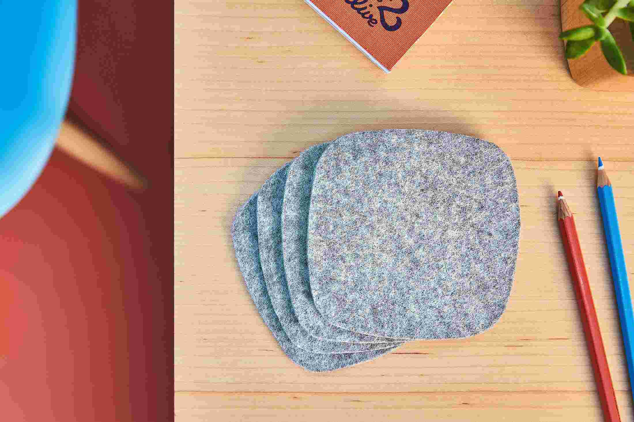 Overhead shot of a set of four premium light wool felt coasters.