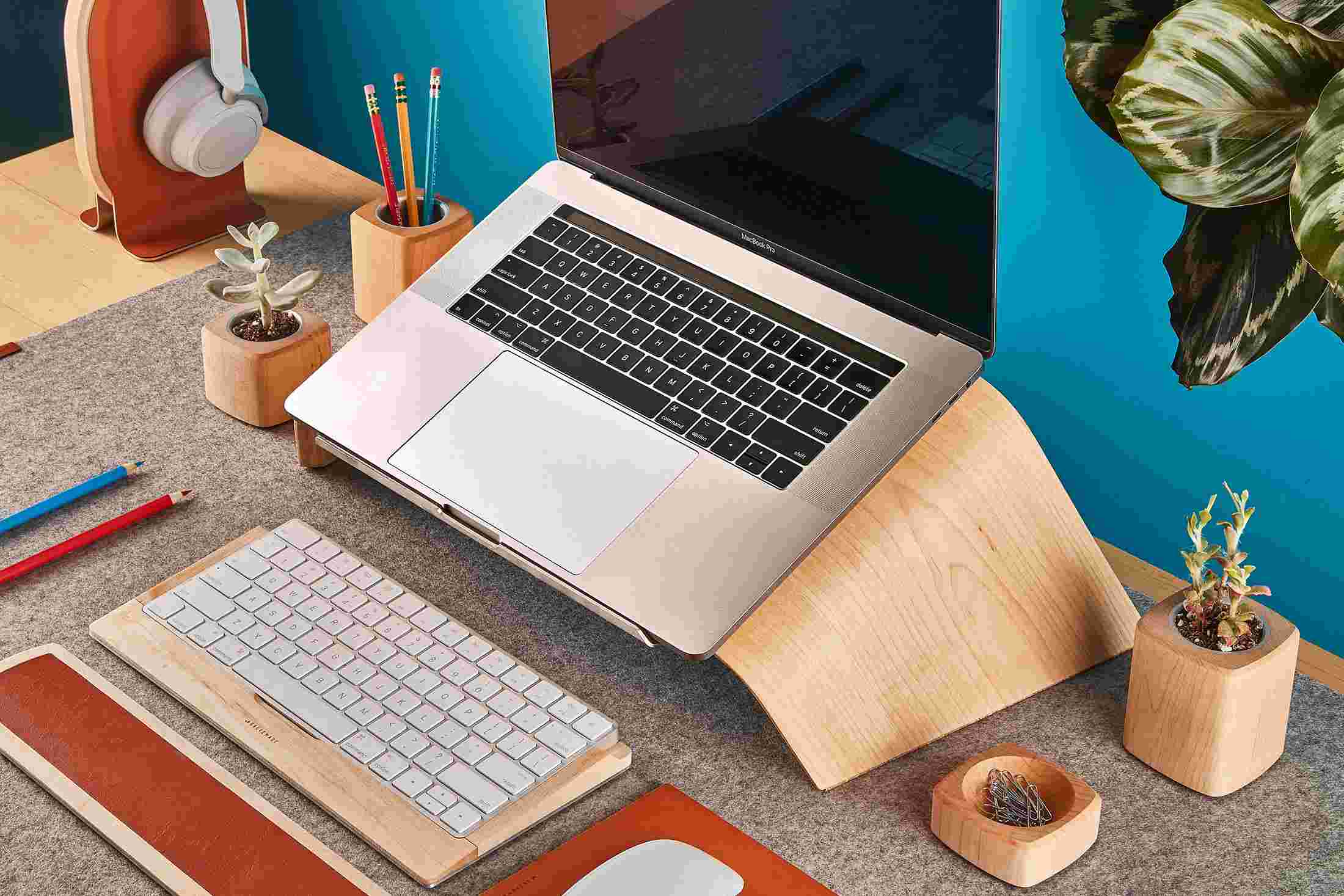 Top view of the maple wood Grovemade Desk Collection with maple laptop stand, pen cups, planters, keyboard tray, and desk lamp.