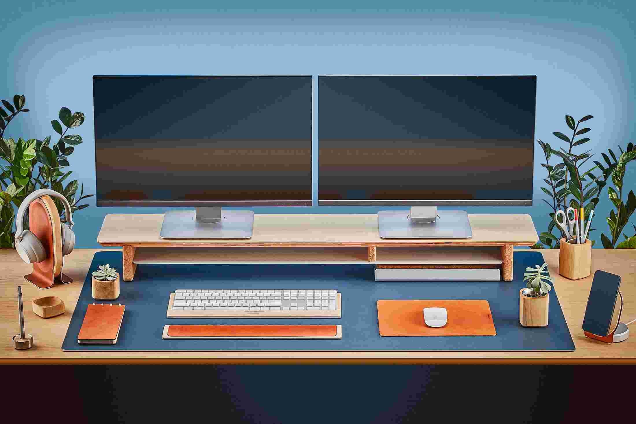 The Extra Large Matte Desk Pad in Navy Blue covering almost an entire desktop, in use with the Maple Desk Shelf System.