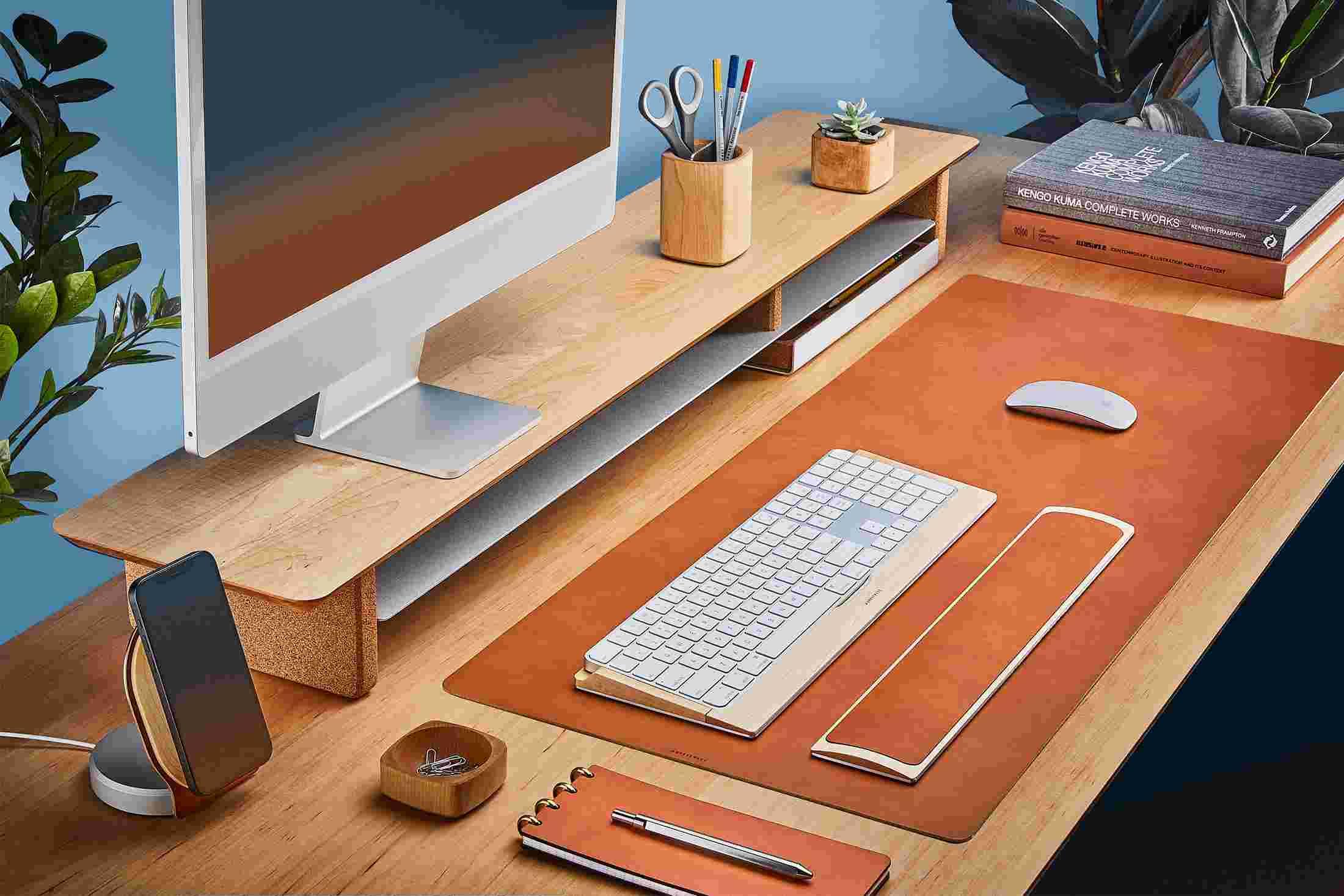 The Medium Wool Felt Desk Pad runs the entire width of a standard desk, pictured here with solid maple wood double-wide monitor stand.