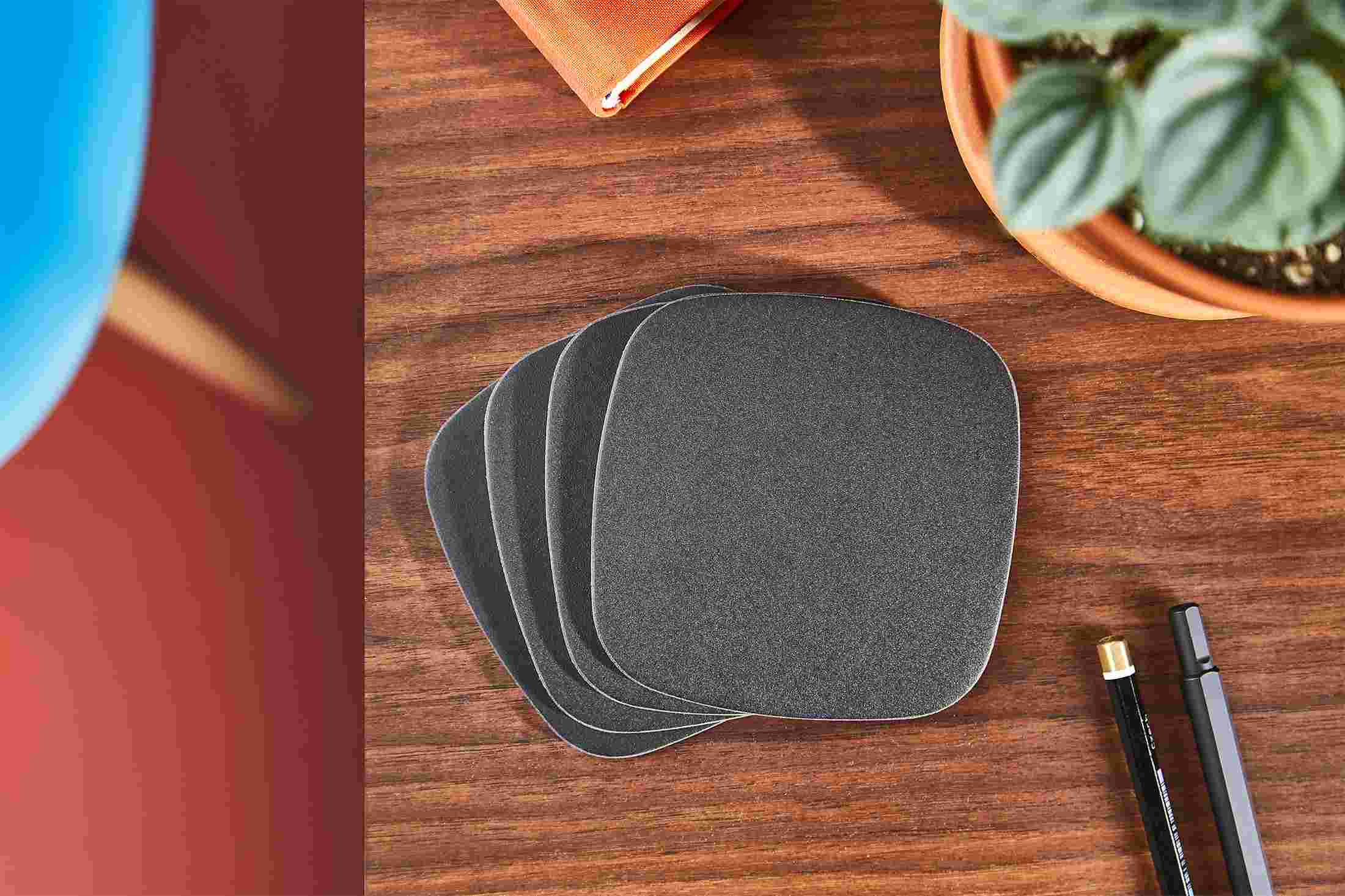 Overhead shot of a set of four premium matte black coasters.