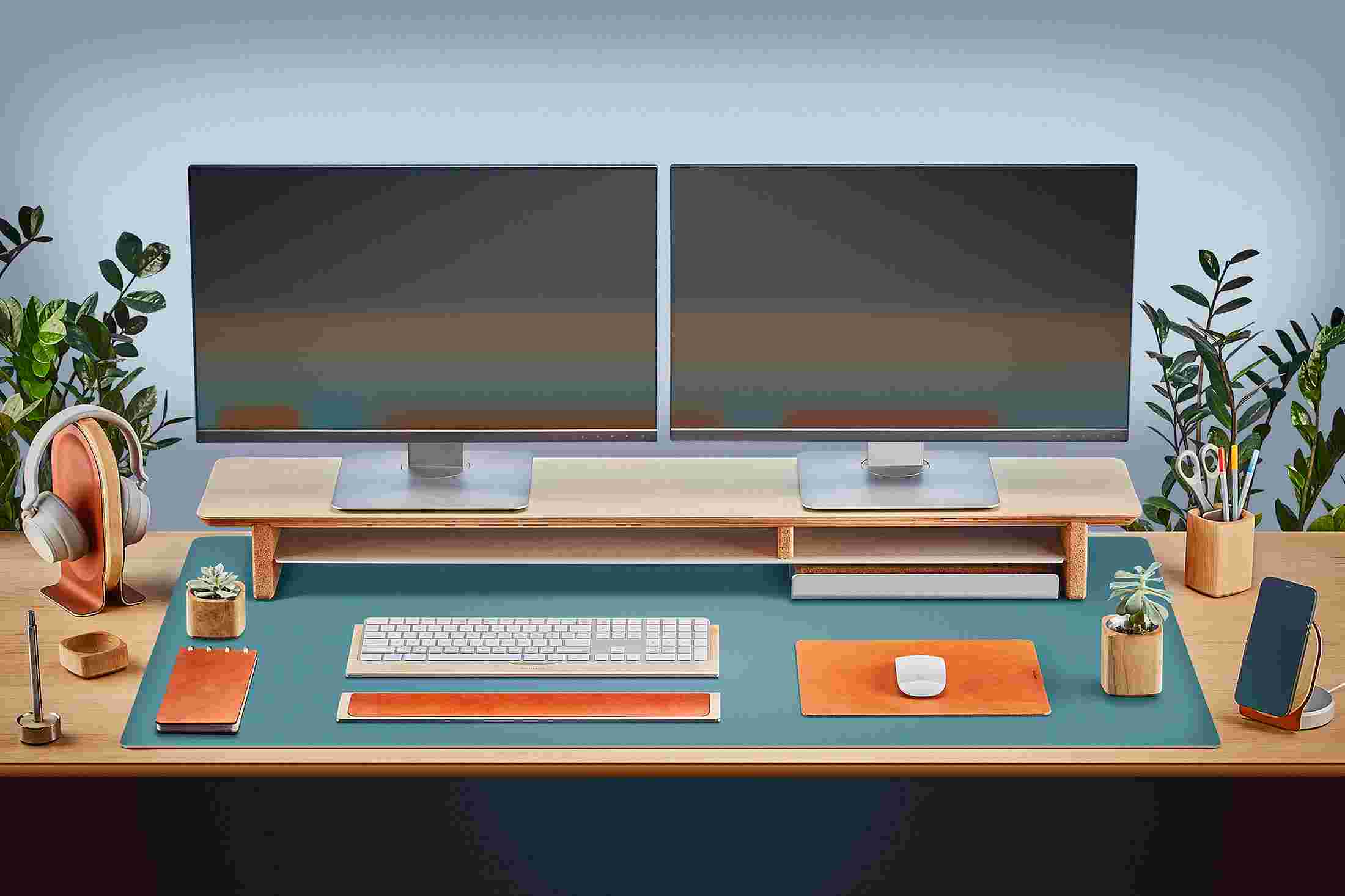 The Extra Large Matte Desk Pad in Light Blue covering almost an entire desktop, in use with the Walnut Desk Shelf System.