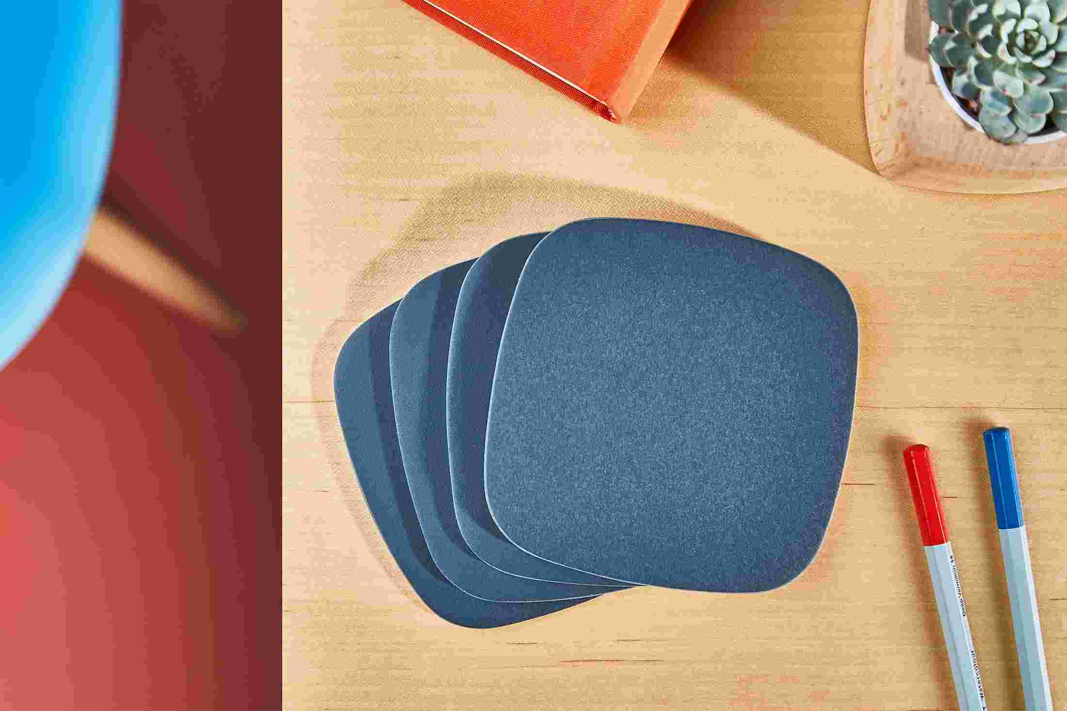 Overhead shot of a set of four premium matte navy blue coasters.