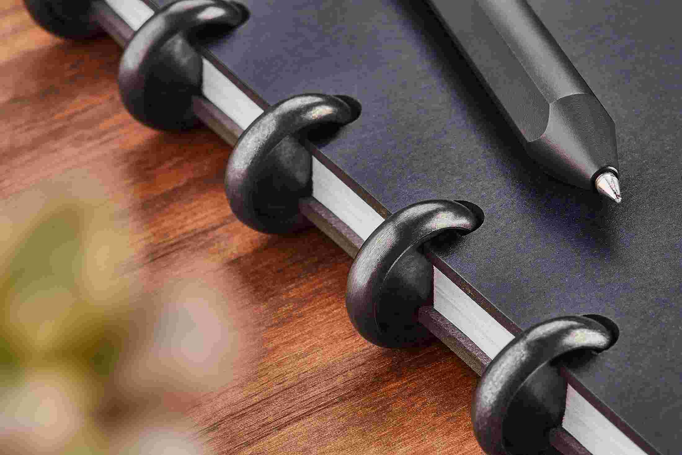 Detail of the black discs on the Grovemade Matte Black Discbound Notebook.